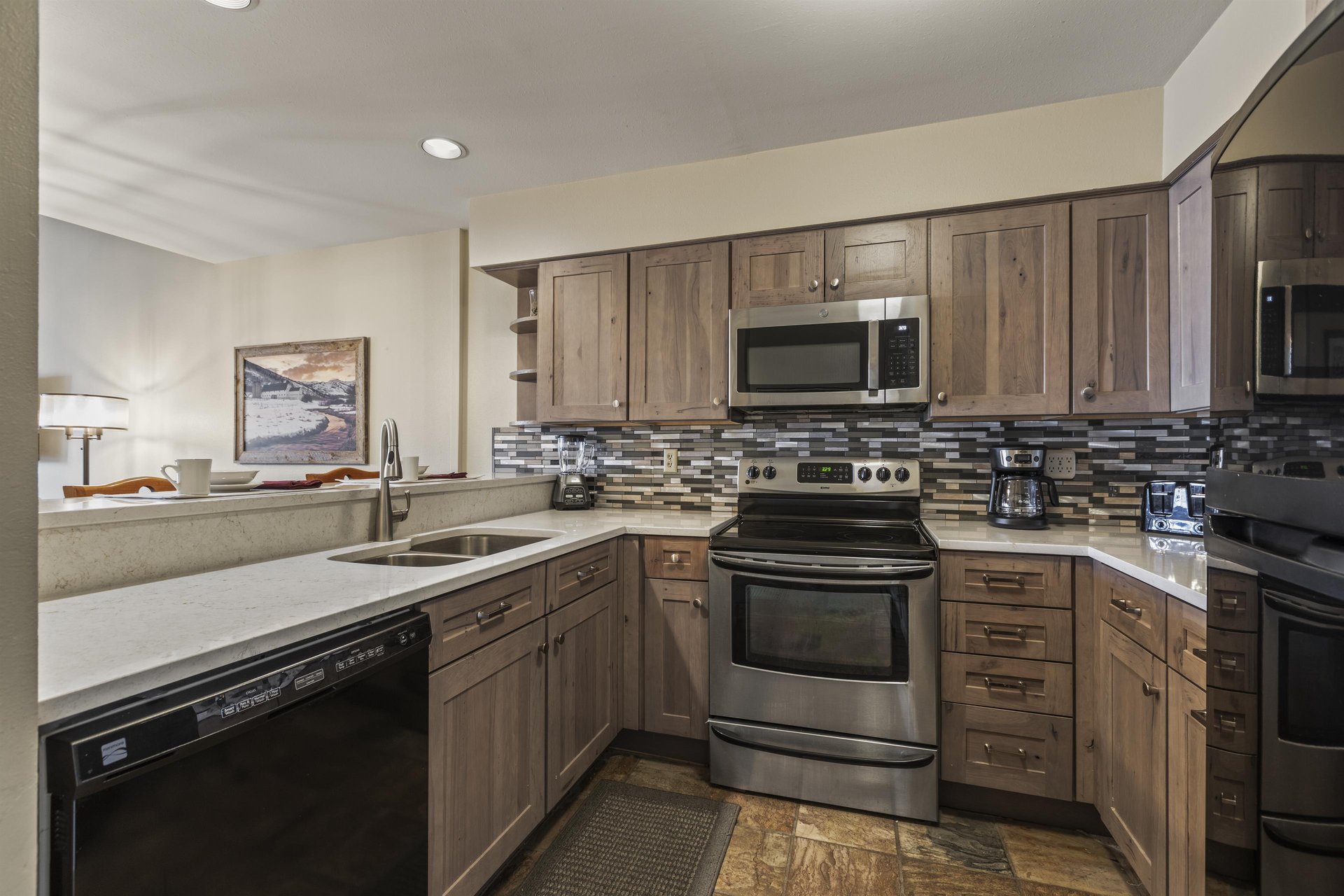Snow Flower 127 has a wellequipped kitchen with wood cabinets and black and stainless steel appliances.