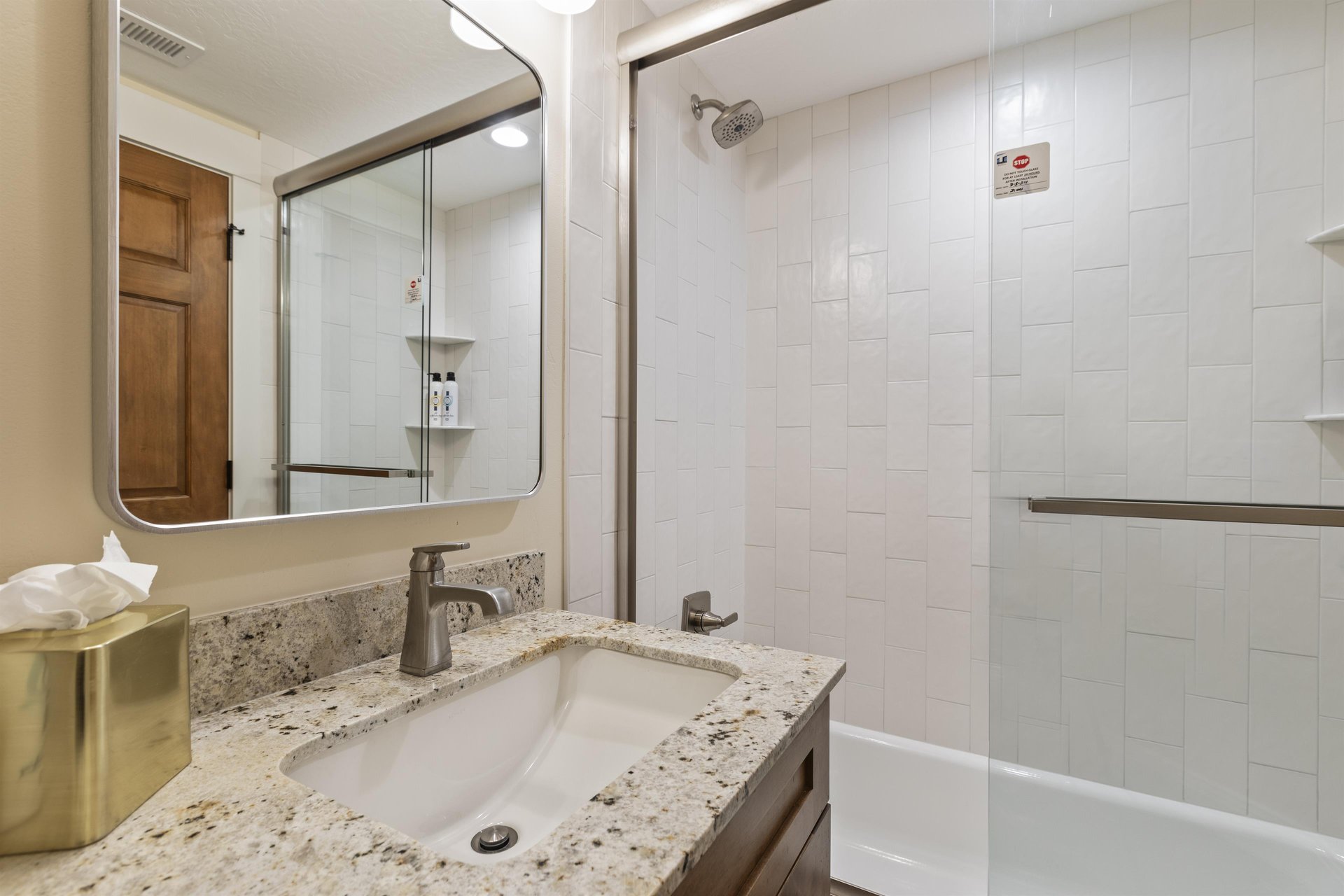 The bathroom with a bathtub and shower combination and single sink vanity
