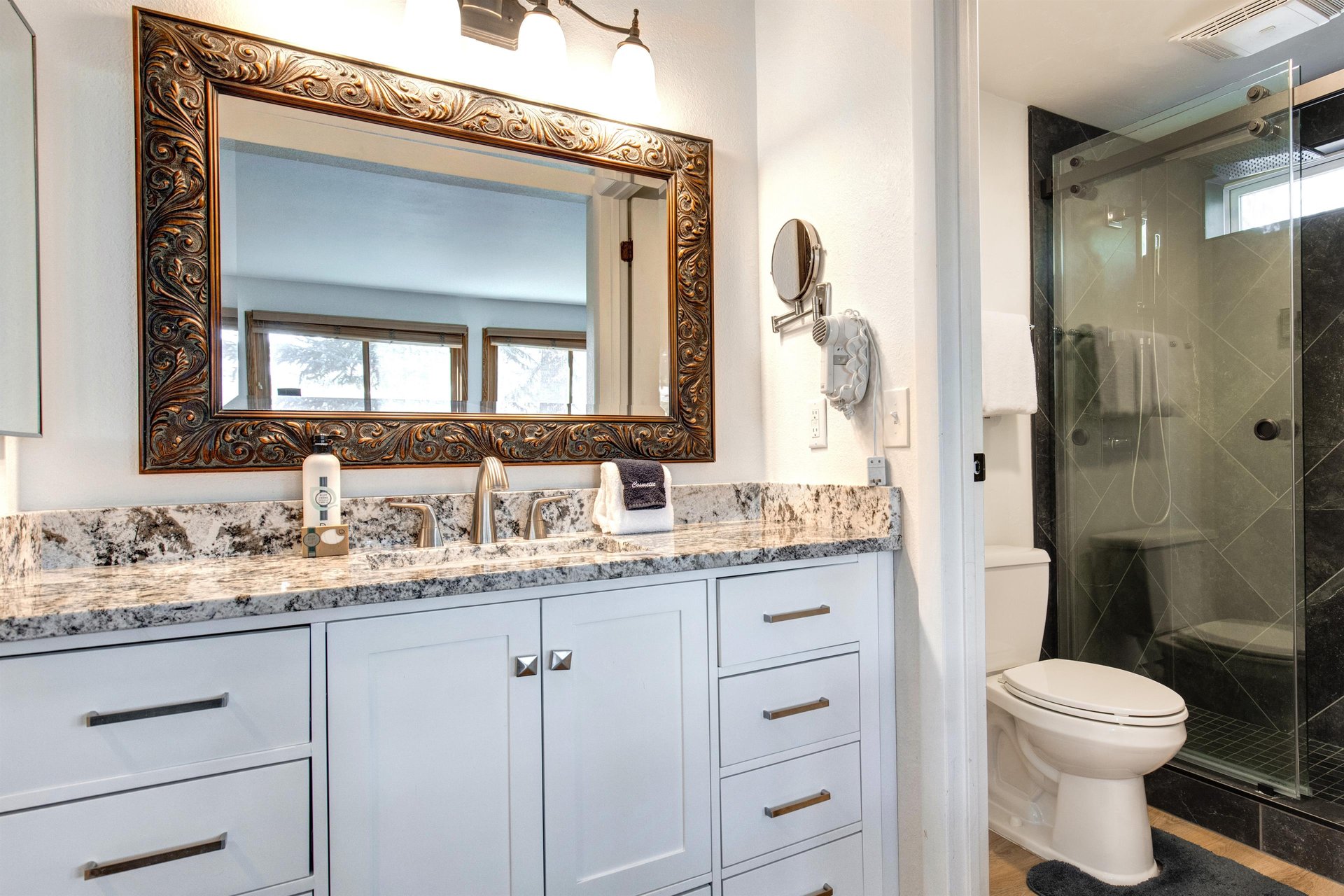The en suite bathroom has a single sink vanity, granite countertops, and a separate water closet.