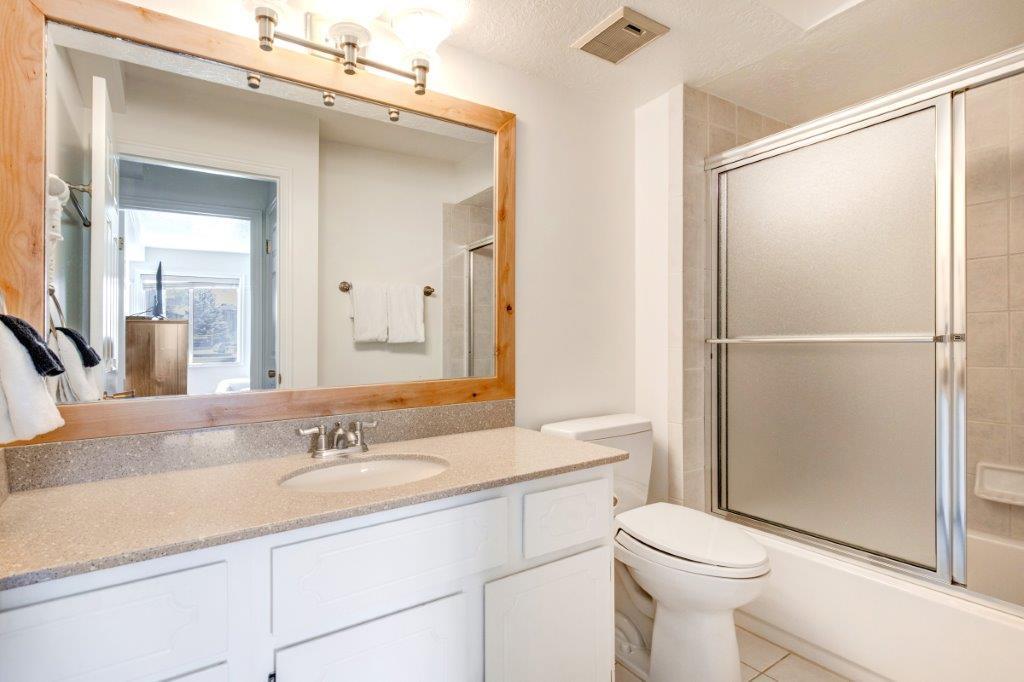 The shared bathroom has a single sink vanity and a bathtub and shower combination.