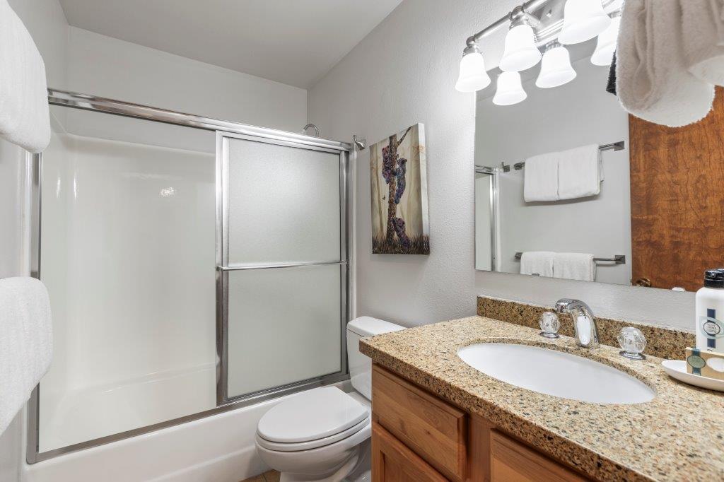 The shared bathroom has a single sink vanity and a bathtub and shower combination.