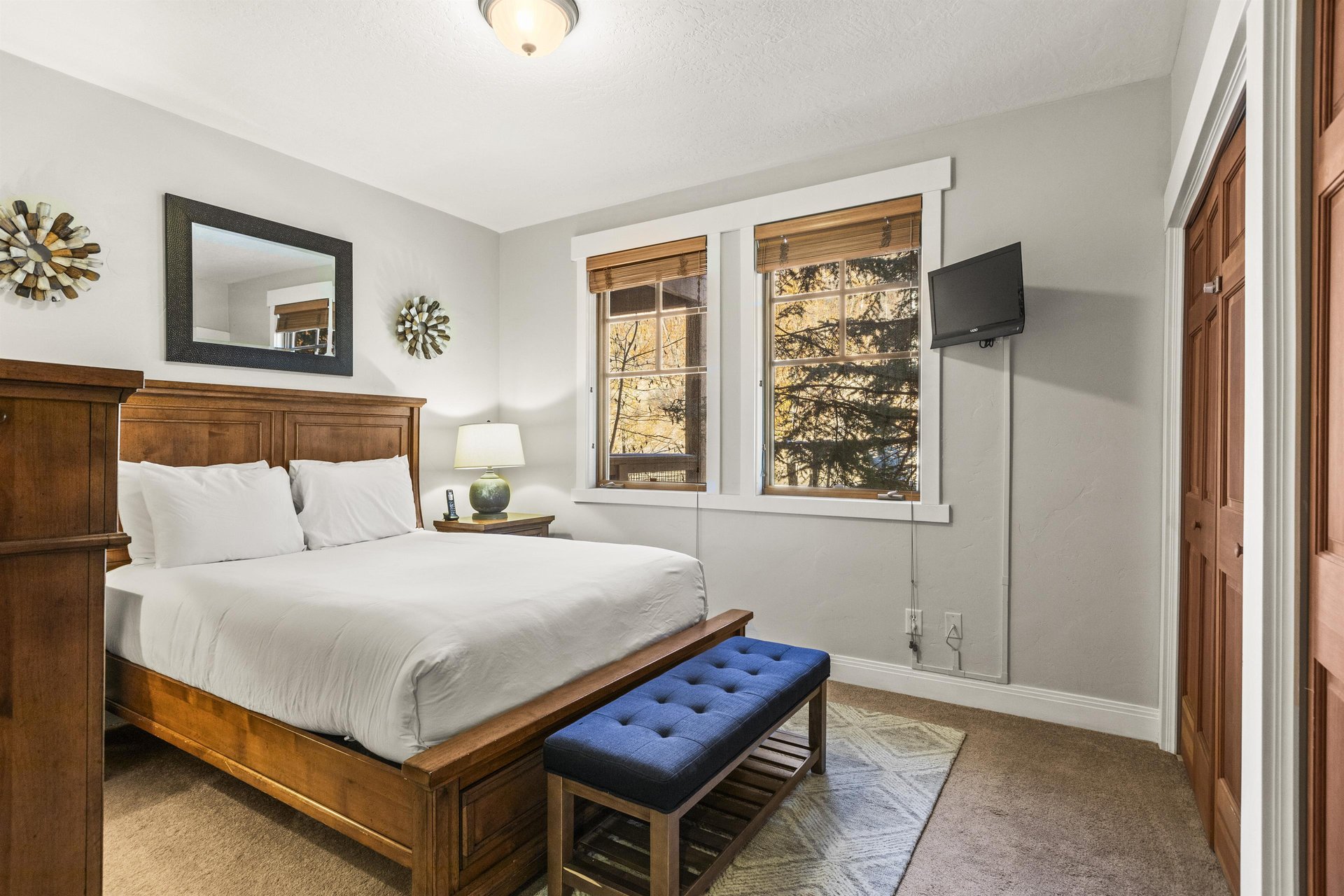 The third bedroom has a queen size bed and wood furniture.