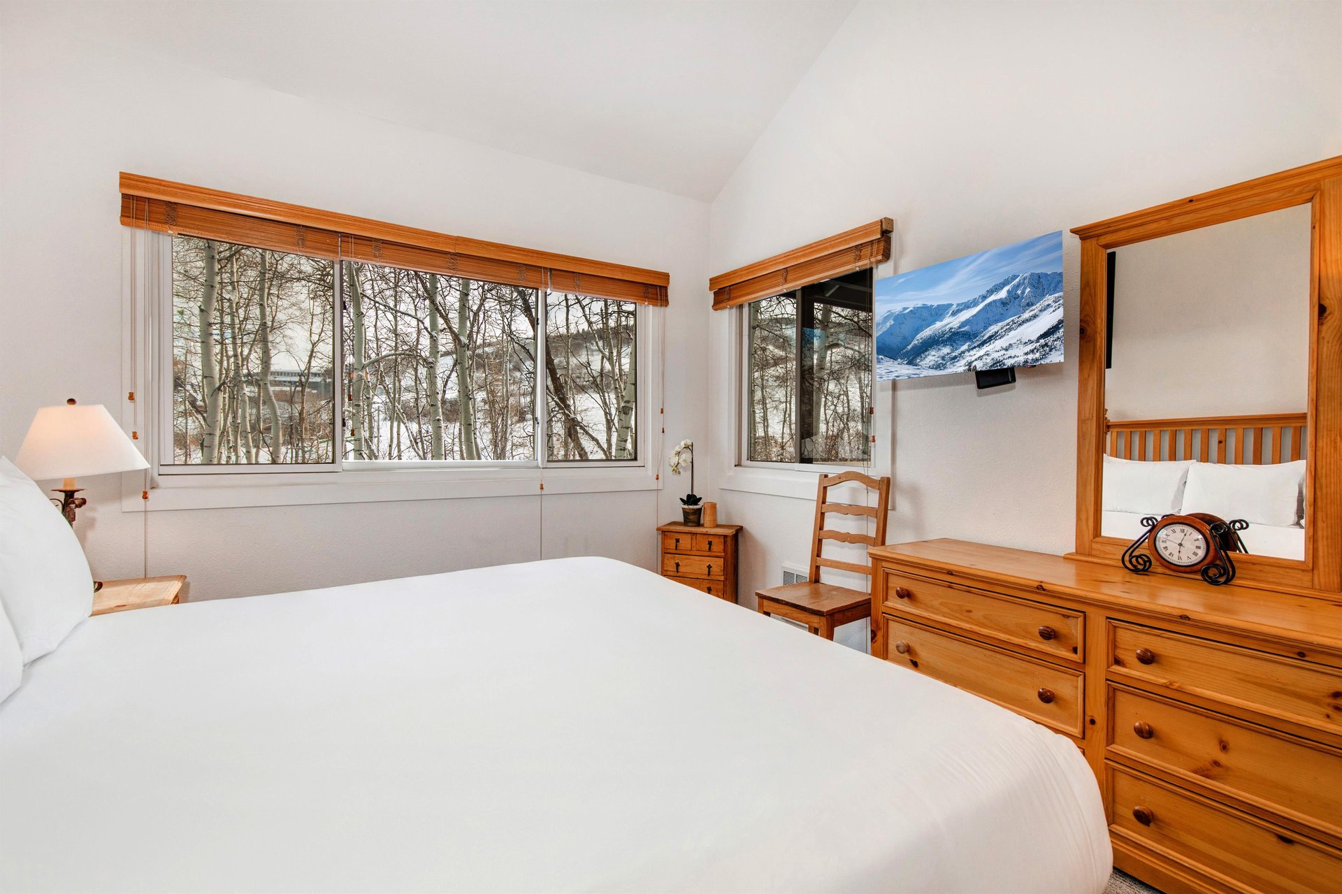 The main suite offers a kingsize bed, wood furniture, and a TV.