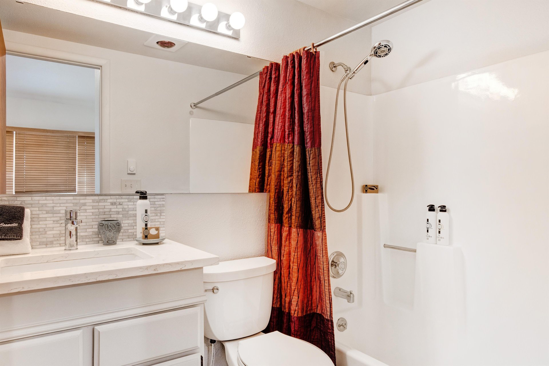 The loft bathroom has a bathtub and shower combination in white.