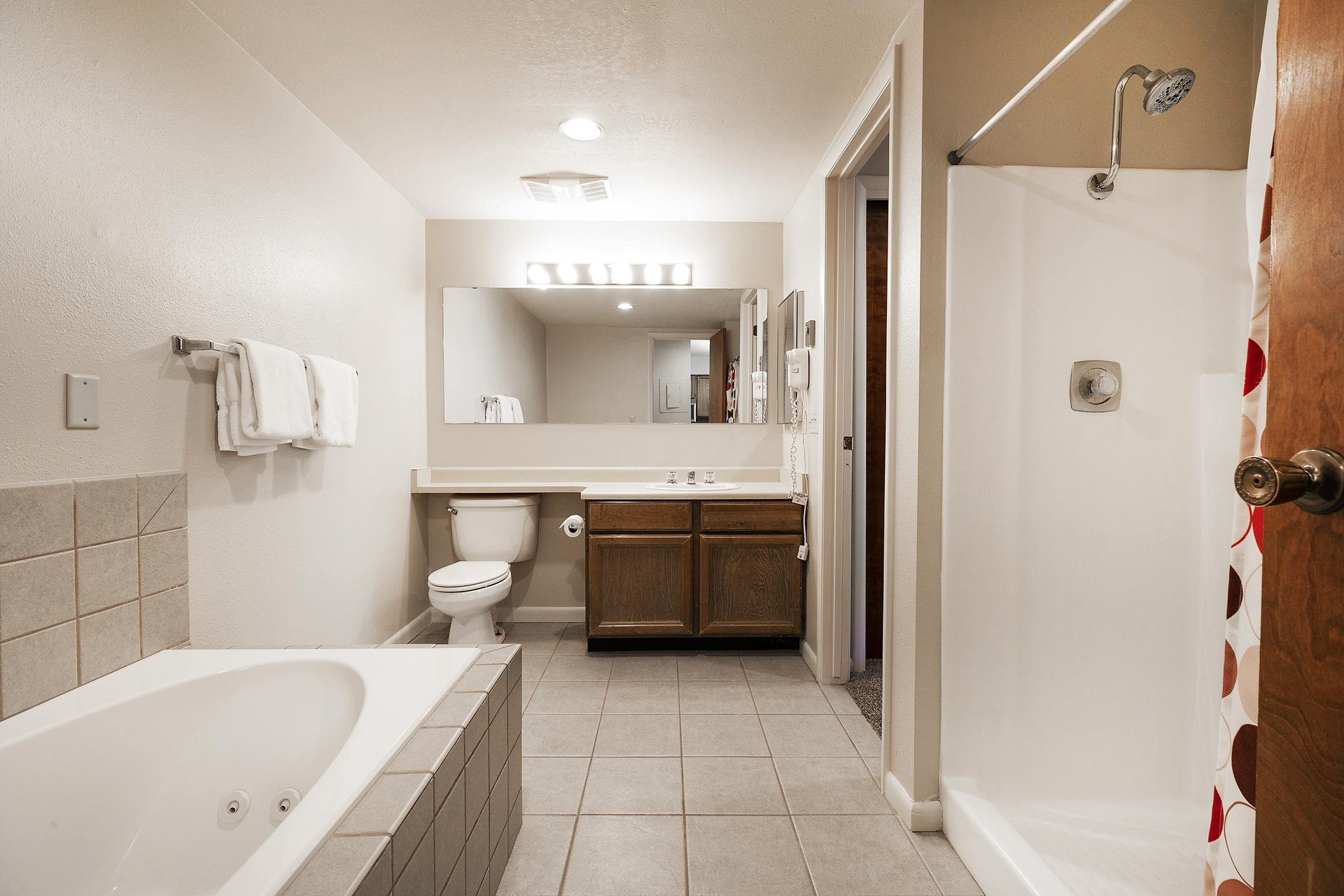 Ensuite main bathroom includes a jetted tub with tile surround and a separate walkin shower
