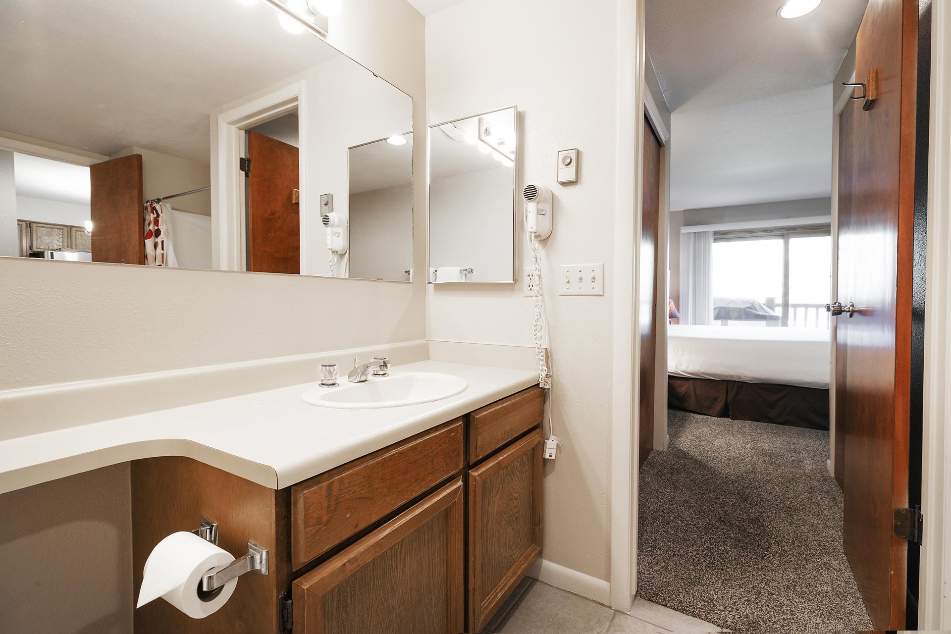 Ensuite main bathroom includes a vanity with white countertops and large mirror