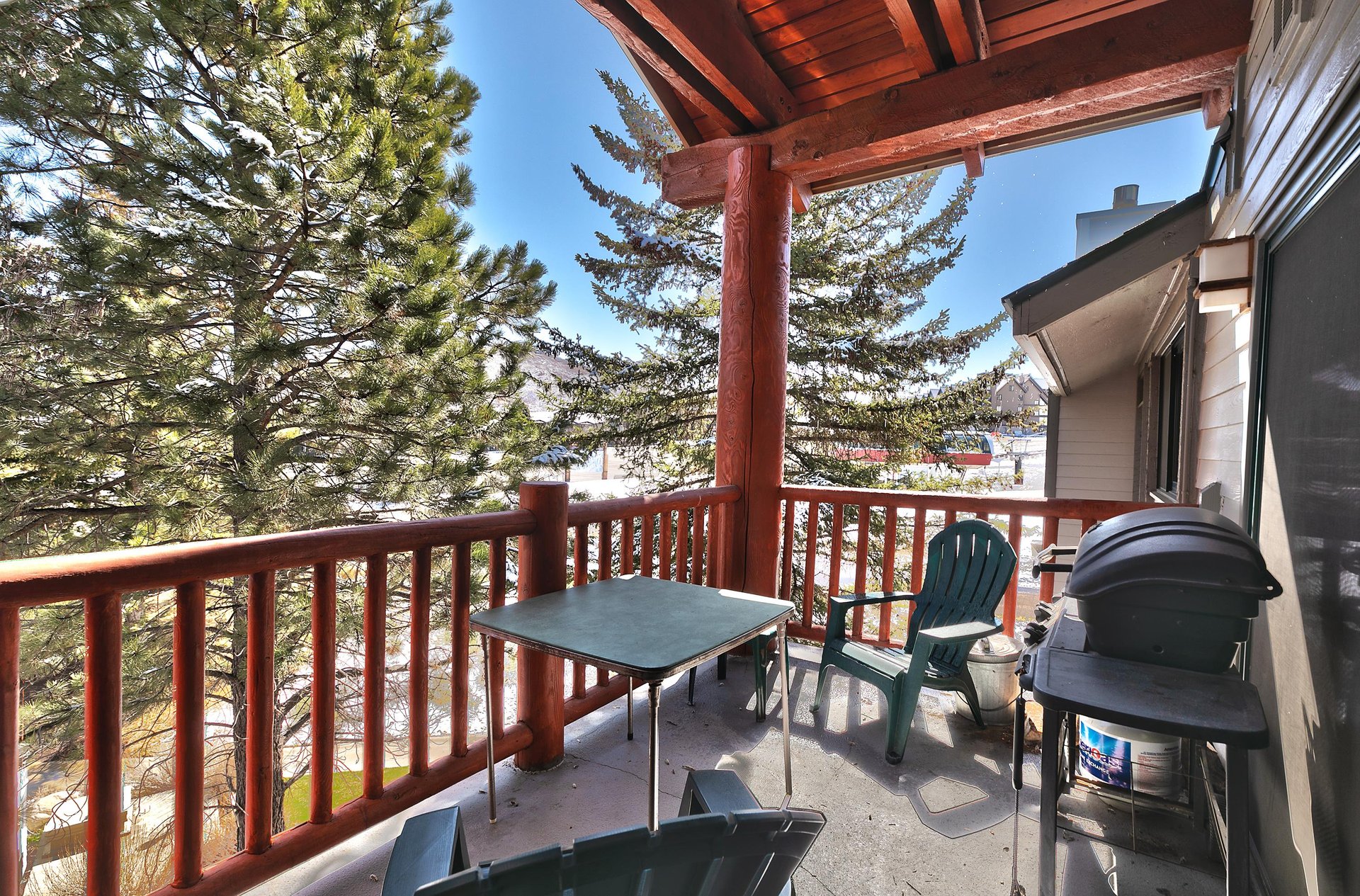 Private patio has green Adirondack chairs and a gas BBQ