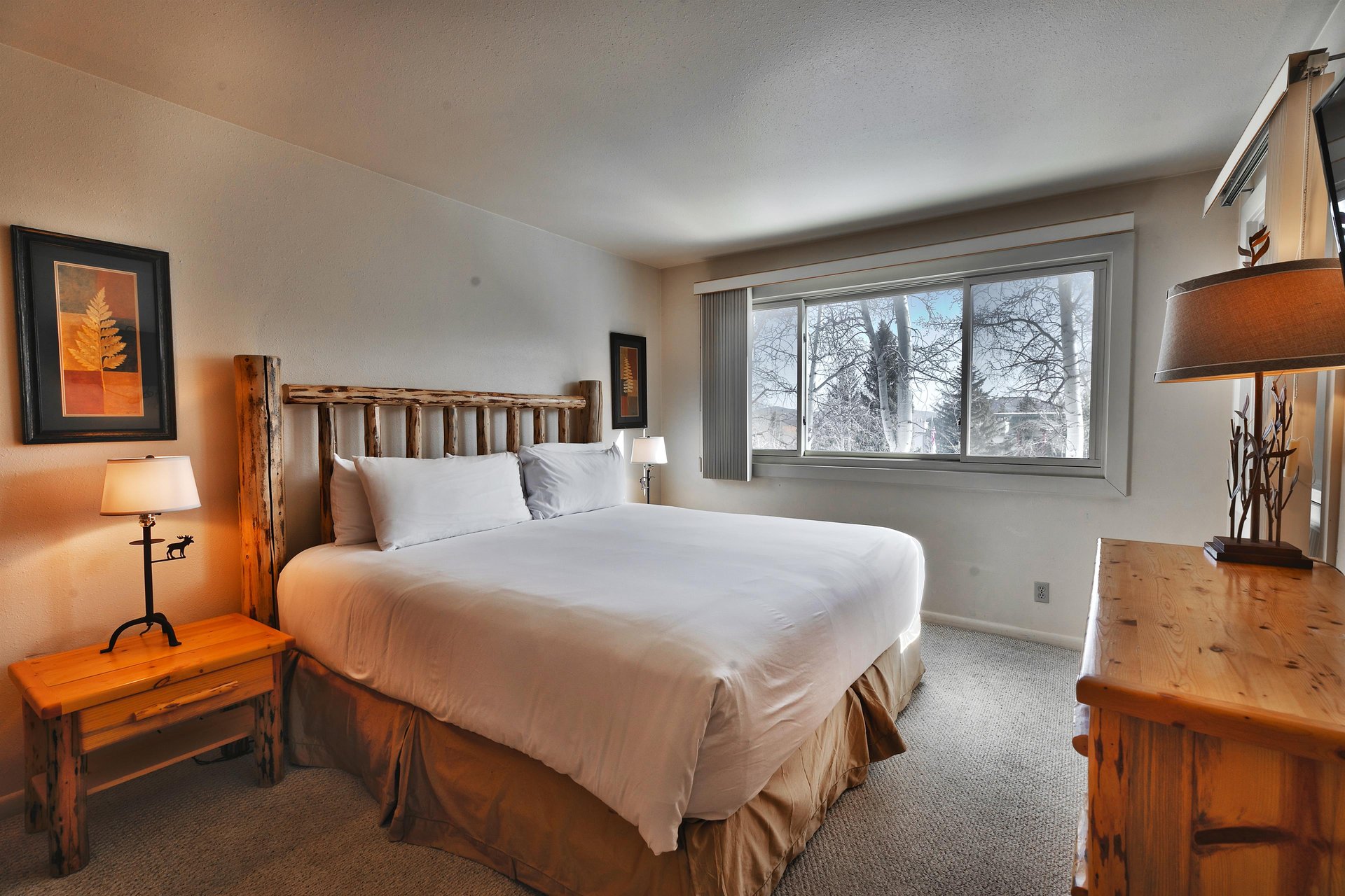 The main bedroom includes a luxurious kingsized bed with a log headboard