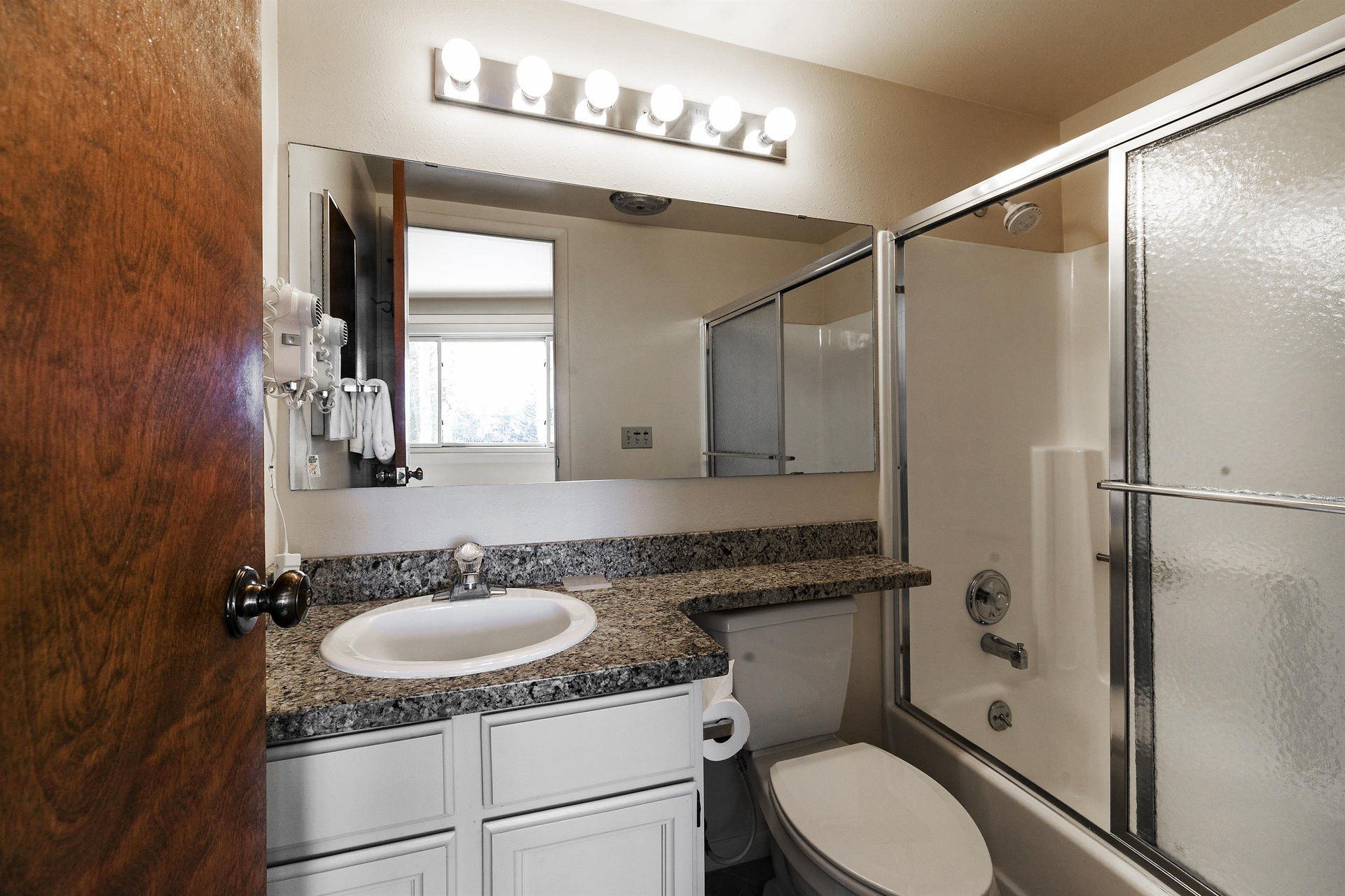 Ensuite main bedroom includes a tubshower combination, white cabinets and granite countertops