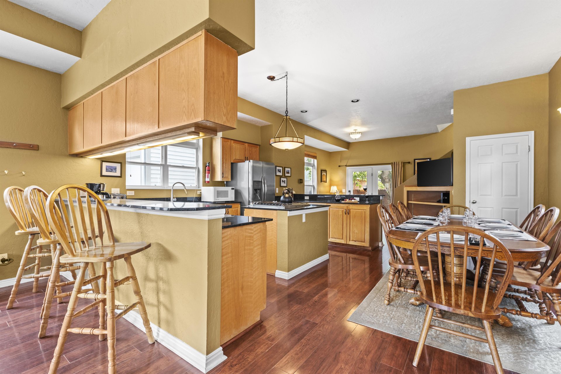 The Ushape kitchen has a center island, a breakfast bar on one side and is open to the dining table.