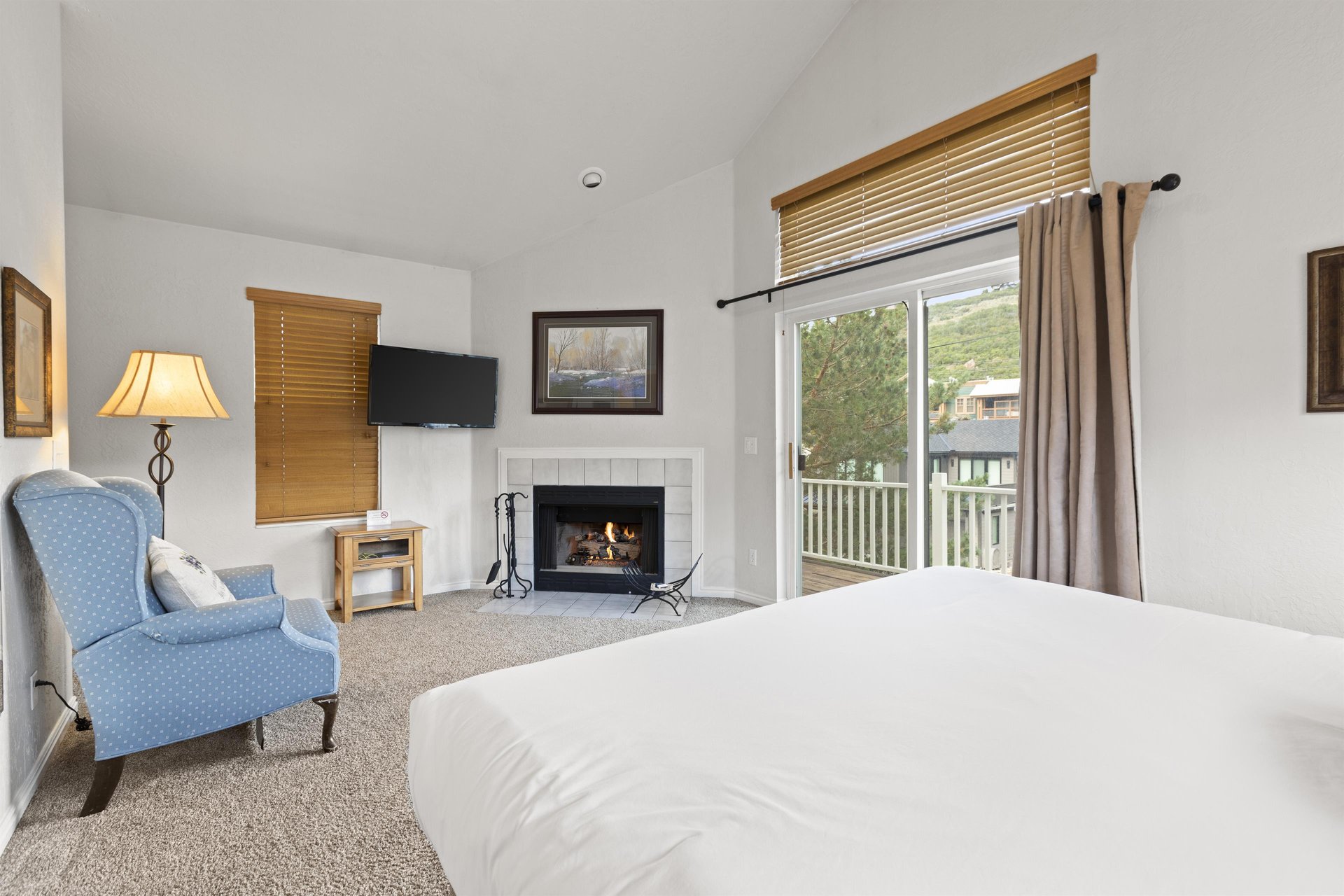 The spacious main suite with a king size bed, large windows, and gas burning fireplace.