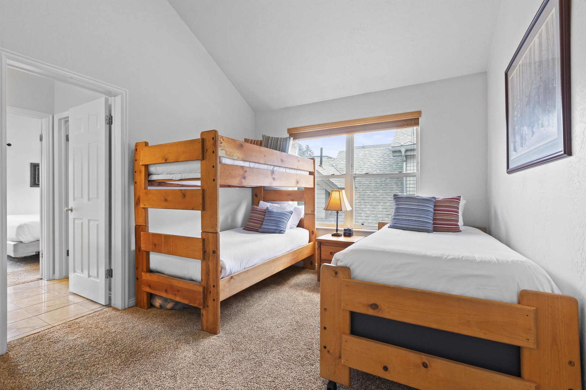 A bedroom has twin bunk beds and an additional twin bed.