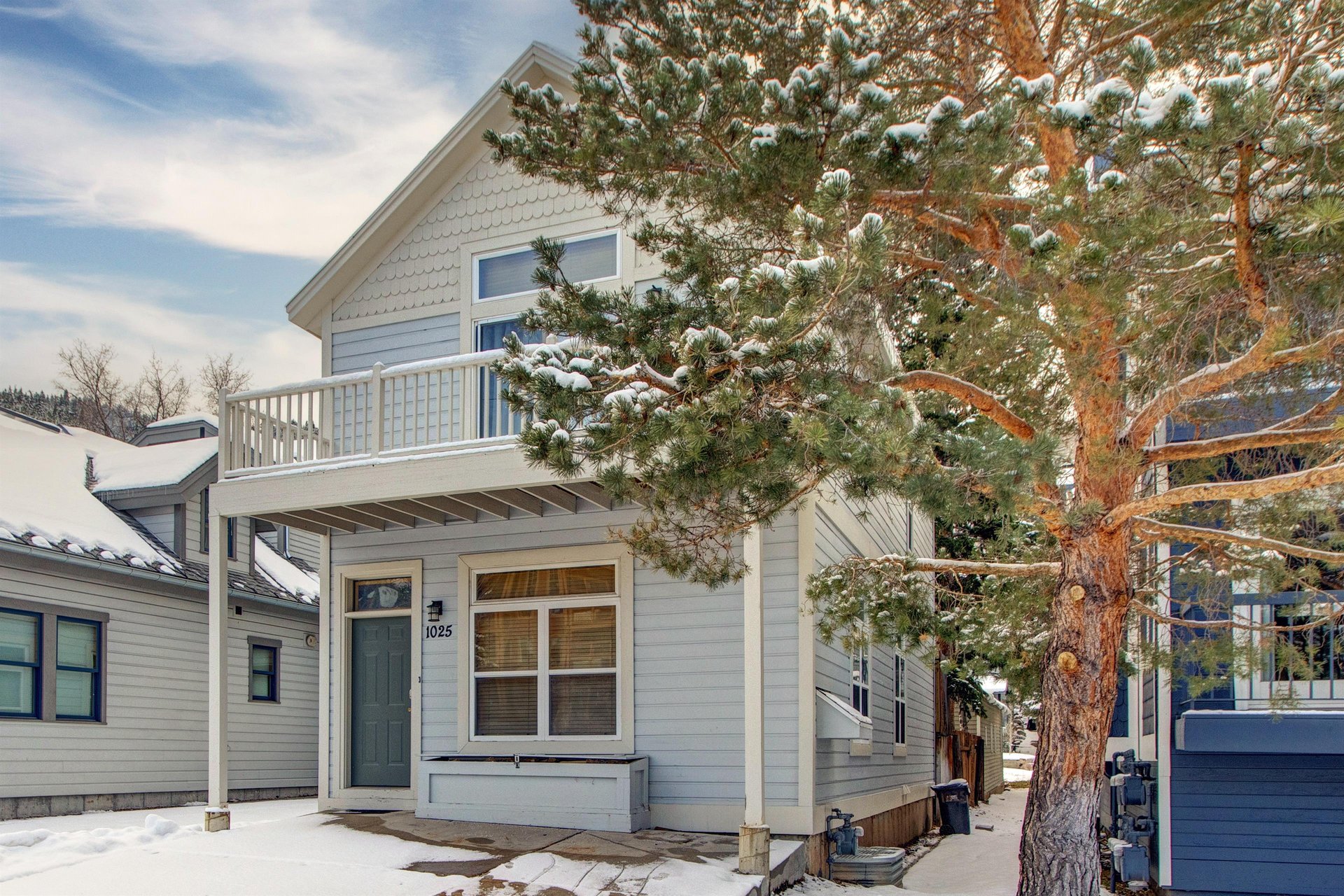 The exterior of the house is light blue with white trim.