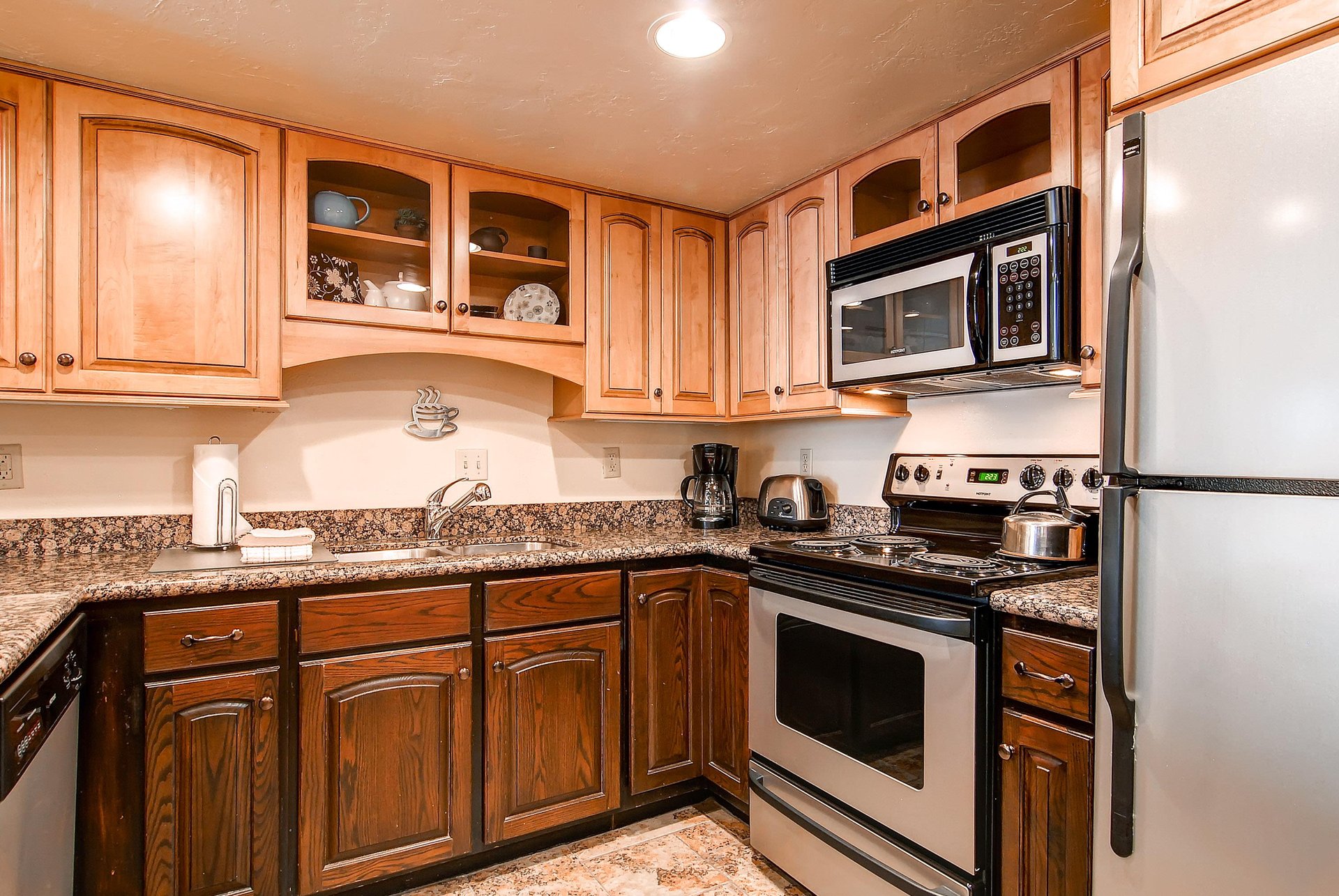 The wellequipped kitchen has wood cabinets and stainless steel appliances.