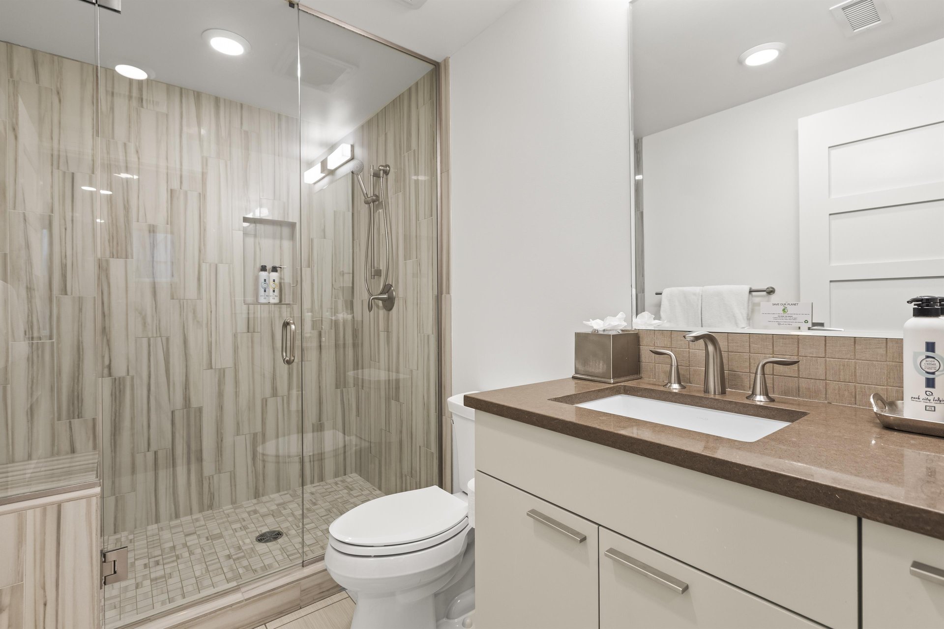 The en suite bathroom has a walk in shower and single sink vanity.