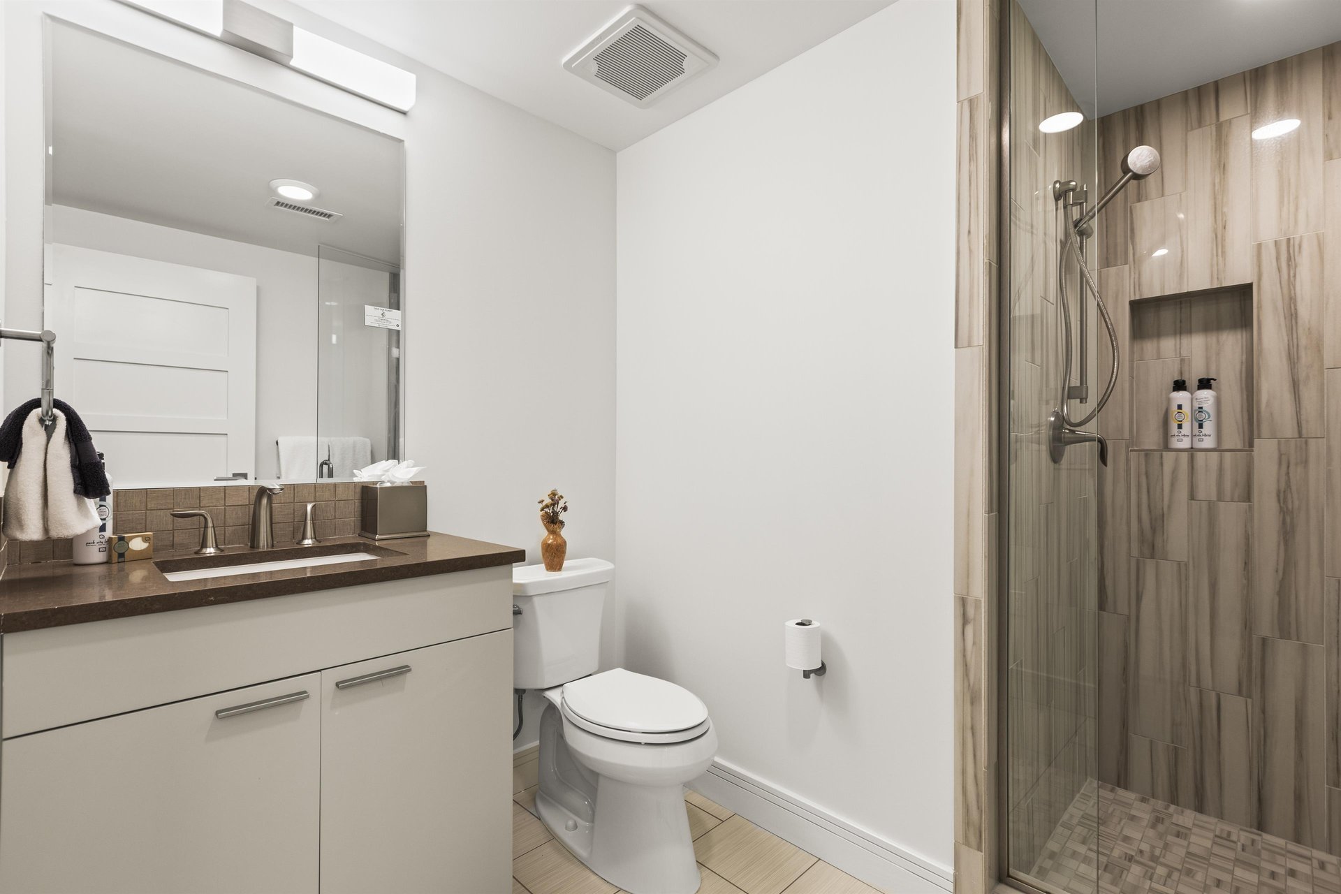 The en suite bathroom has a walk in shower and single sink vanity.