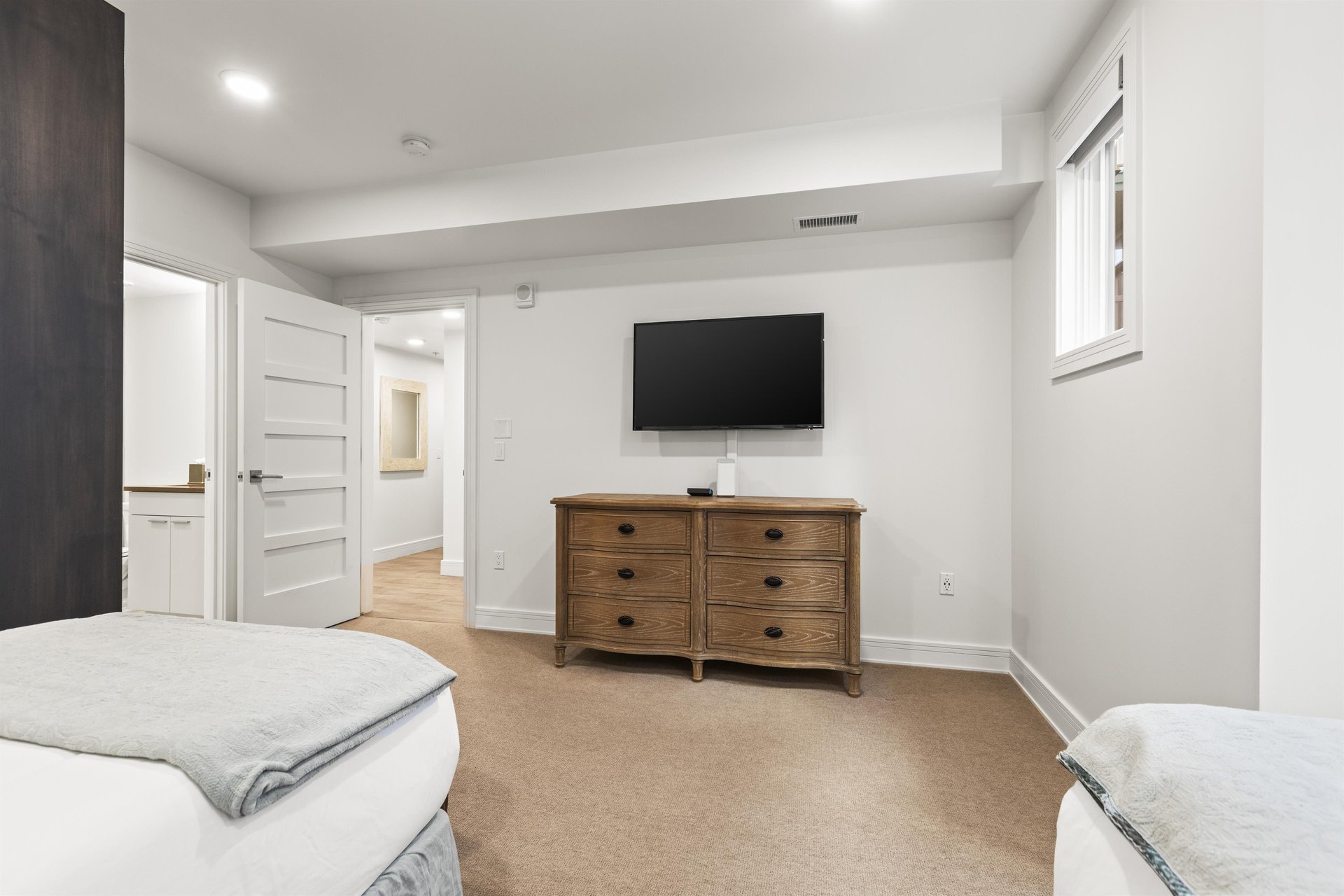 A second bedroom offers two twin beds, wooden dresser and flat screen TV.