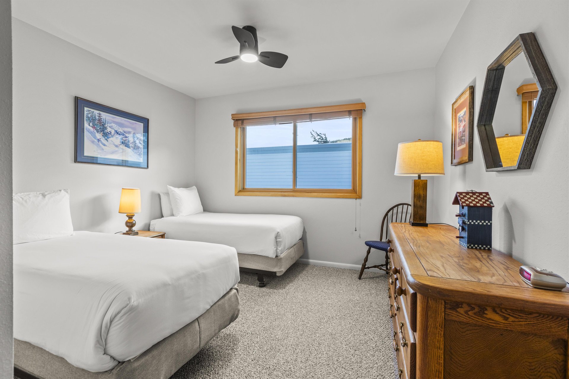 The bedroom offers two twin size beds and a wooden vanity.