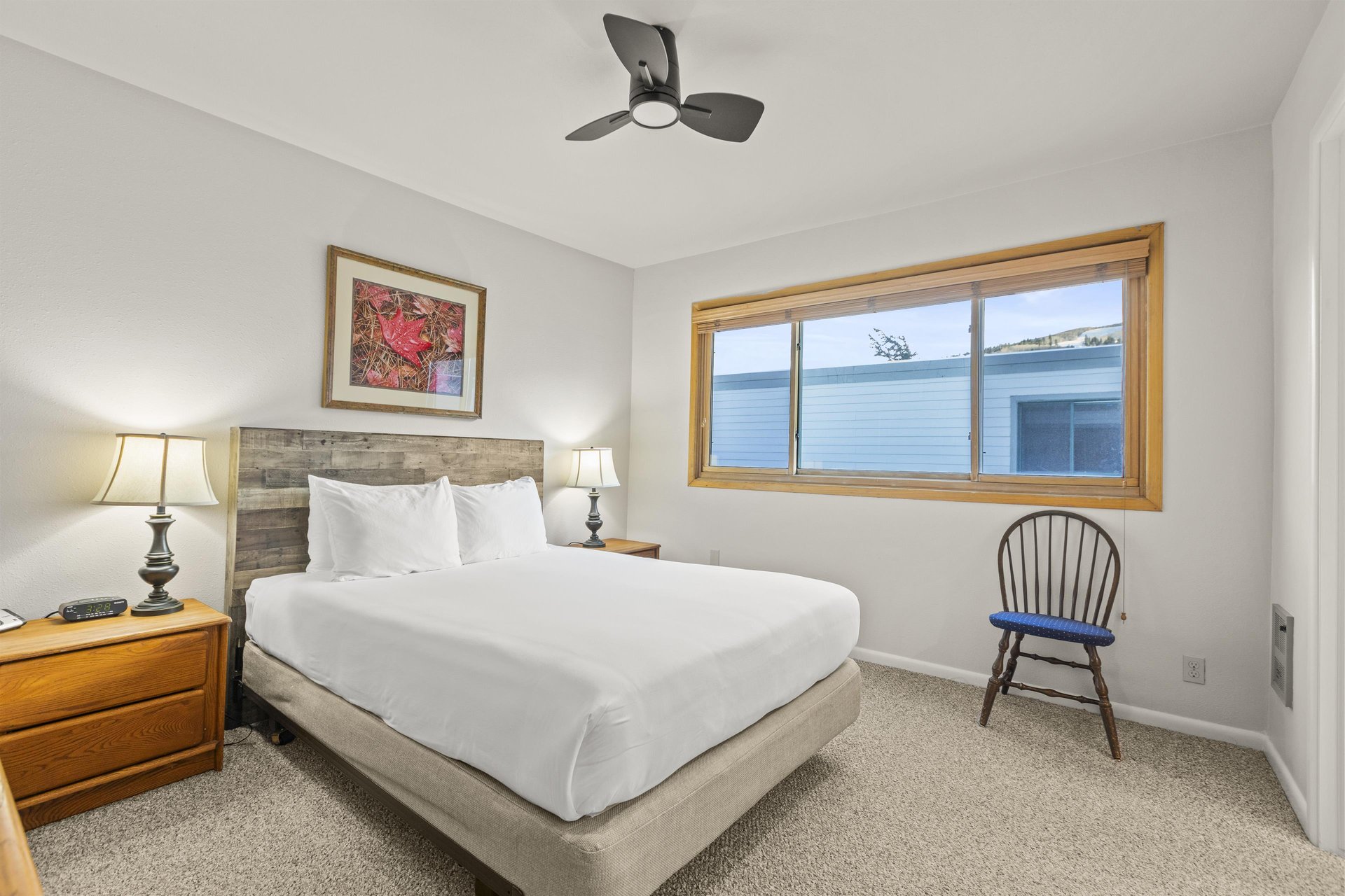 The bedroom with a queen size bed and wood headboard.