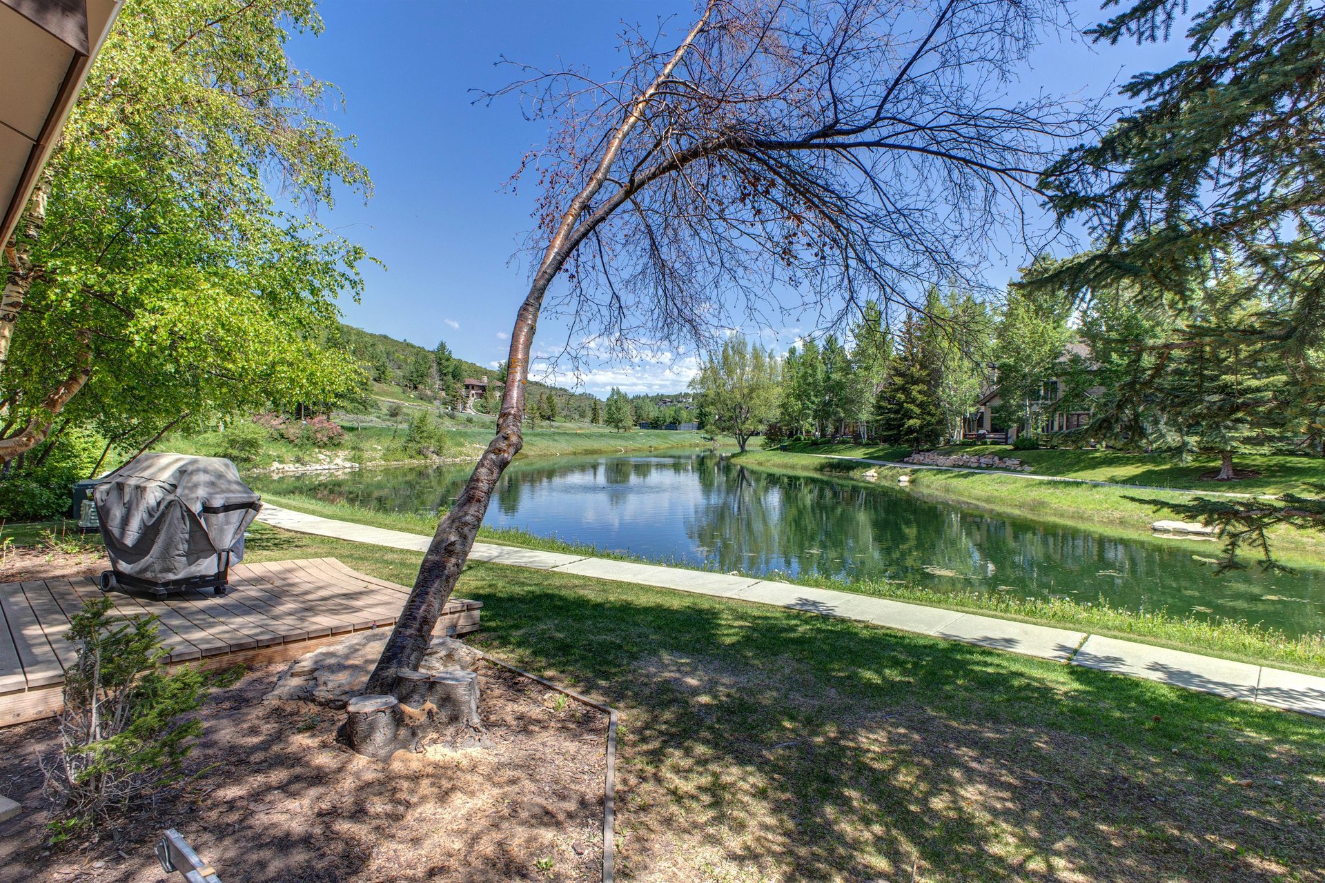 Queen Esther 2425 sits peacefully along a small lake surrounded by trees and greenery.