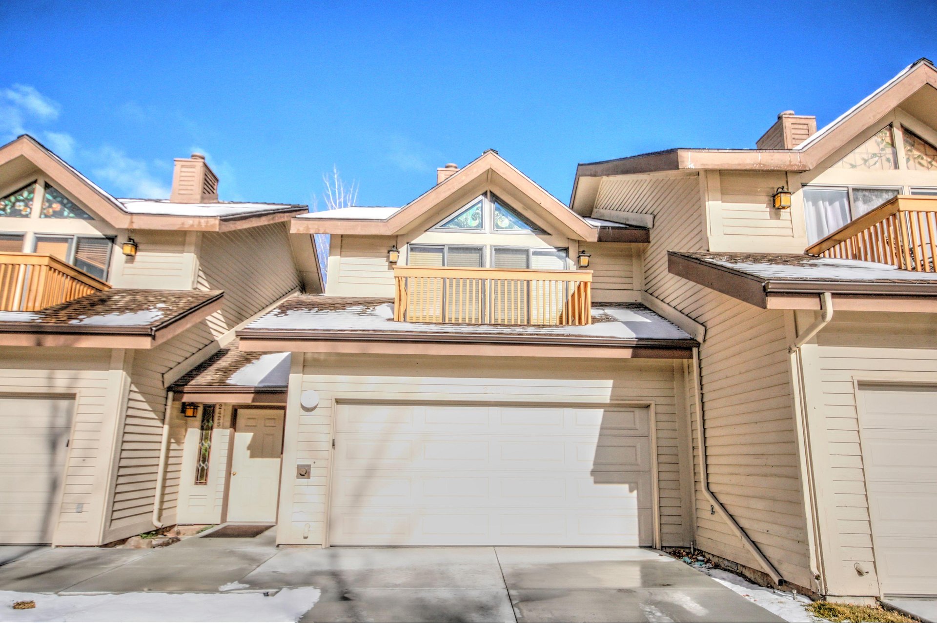 The cream colored exterior has private garage parking for two cars.