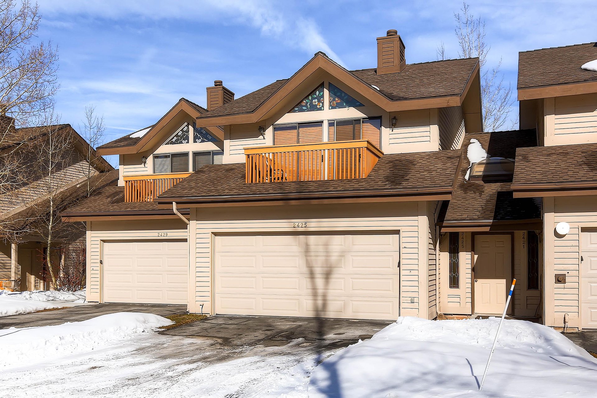 The cream colored exterior has private garage parking for two cars.