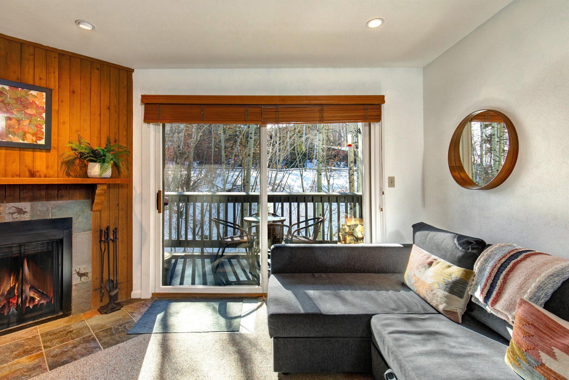 The living room has comfortable couches, gas burning fireplace and views of the aspen grove.