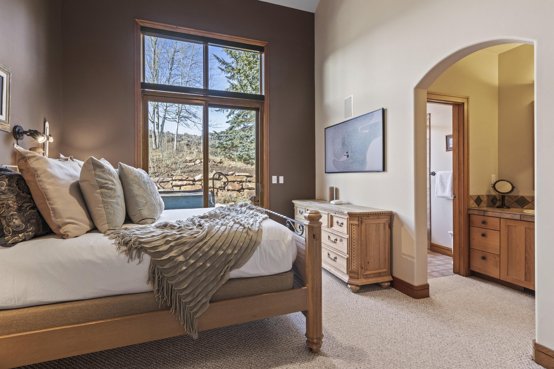 The second bedroom with a queen size bed and access to a private patio with a hot tub.