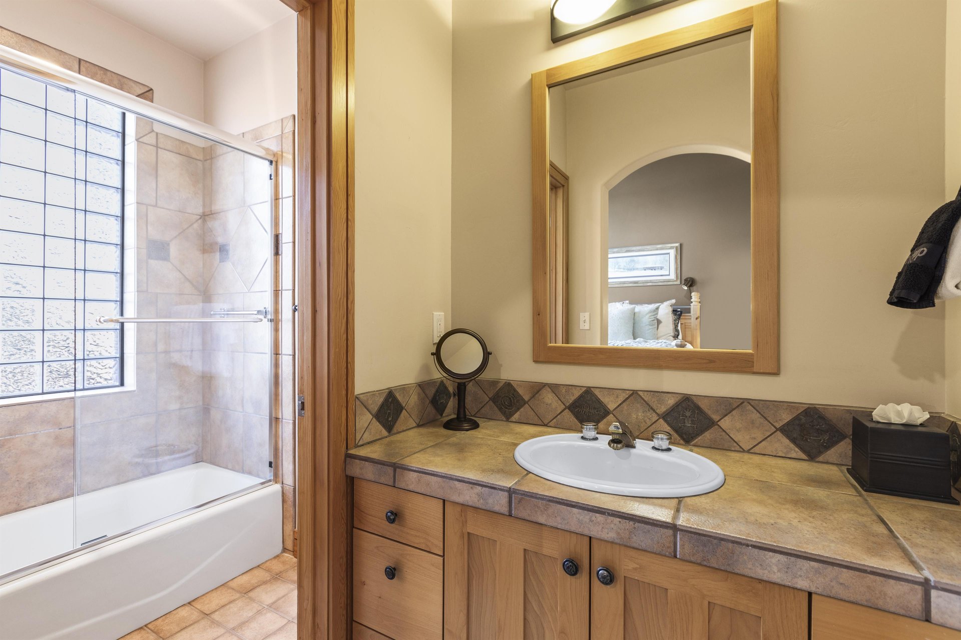 The en suite bathroom with a single sink vanity and bathtub and shower combo.