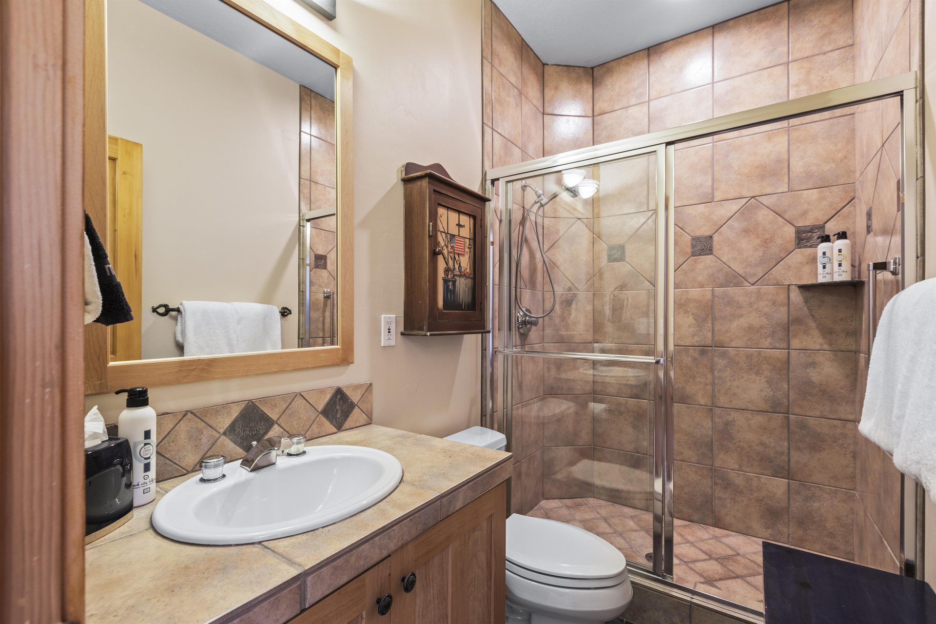 The en suite bathroom has a walk in shower and single sink vanity.