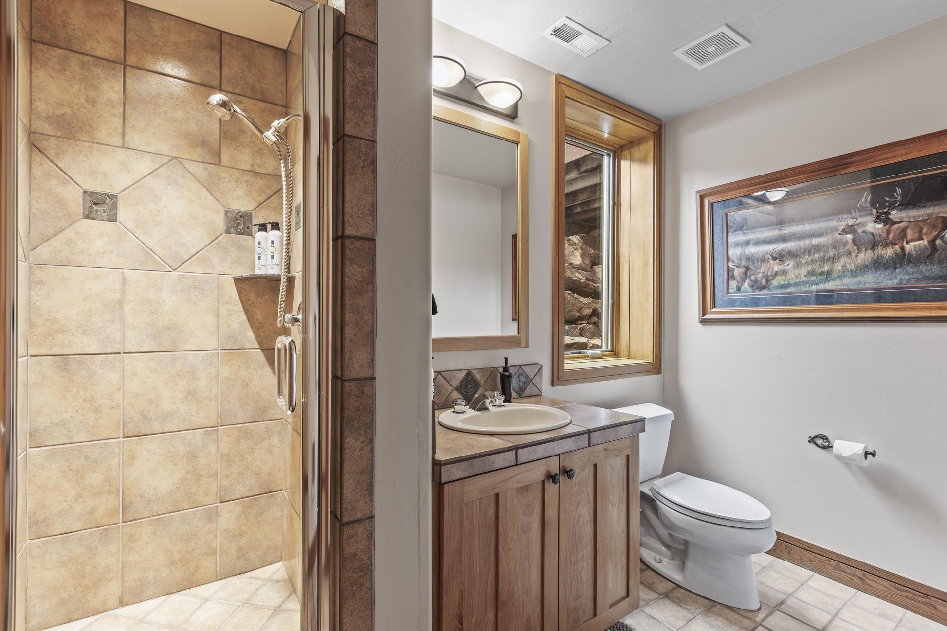 The shared bathroom has a walkin shower and single sink vanity.