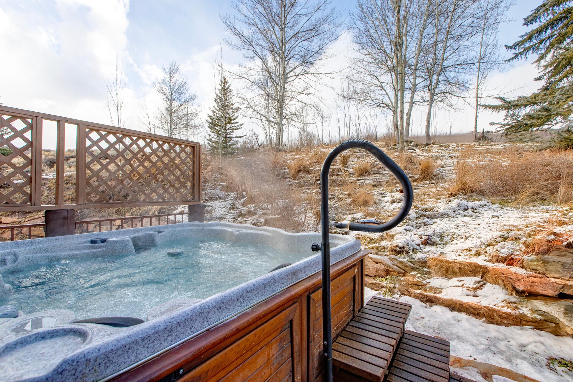 A private hot tub with serene views of the hillside.