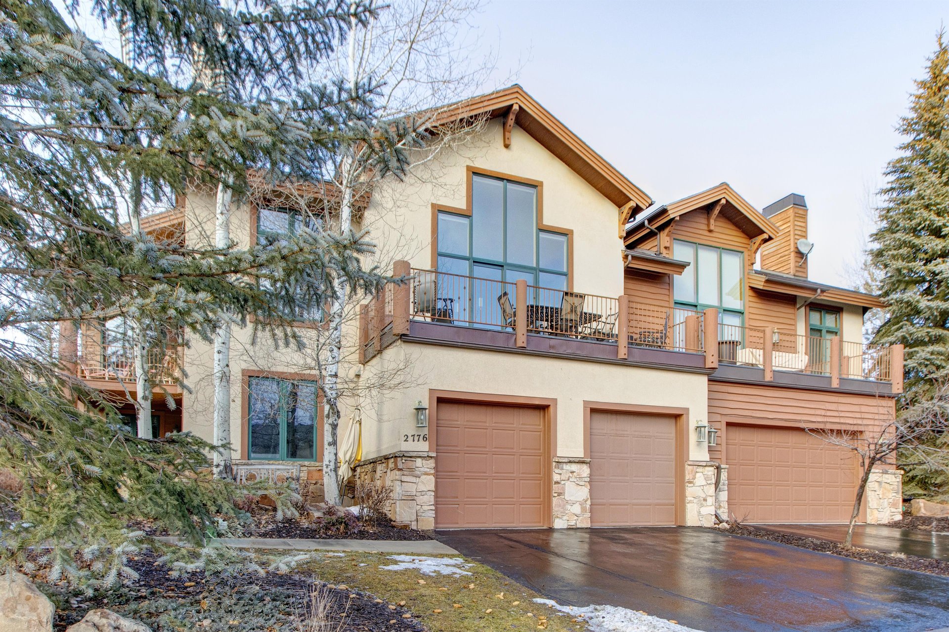 The exterior of the townhome with a two car garage and outside patio on the second level.
