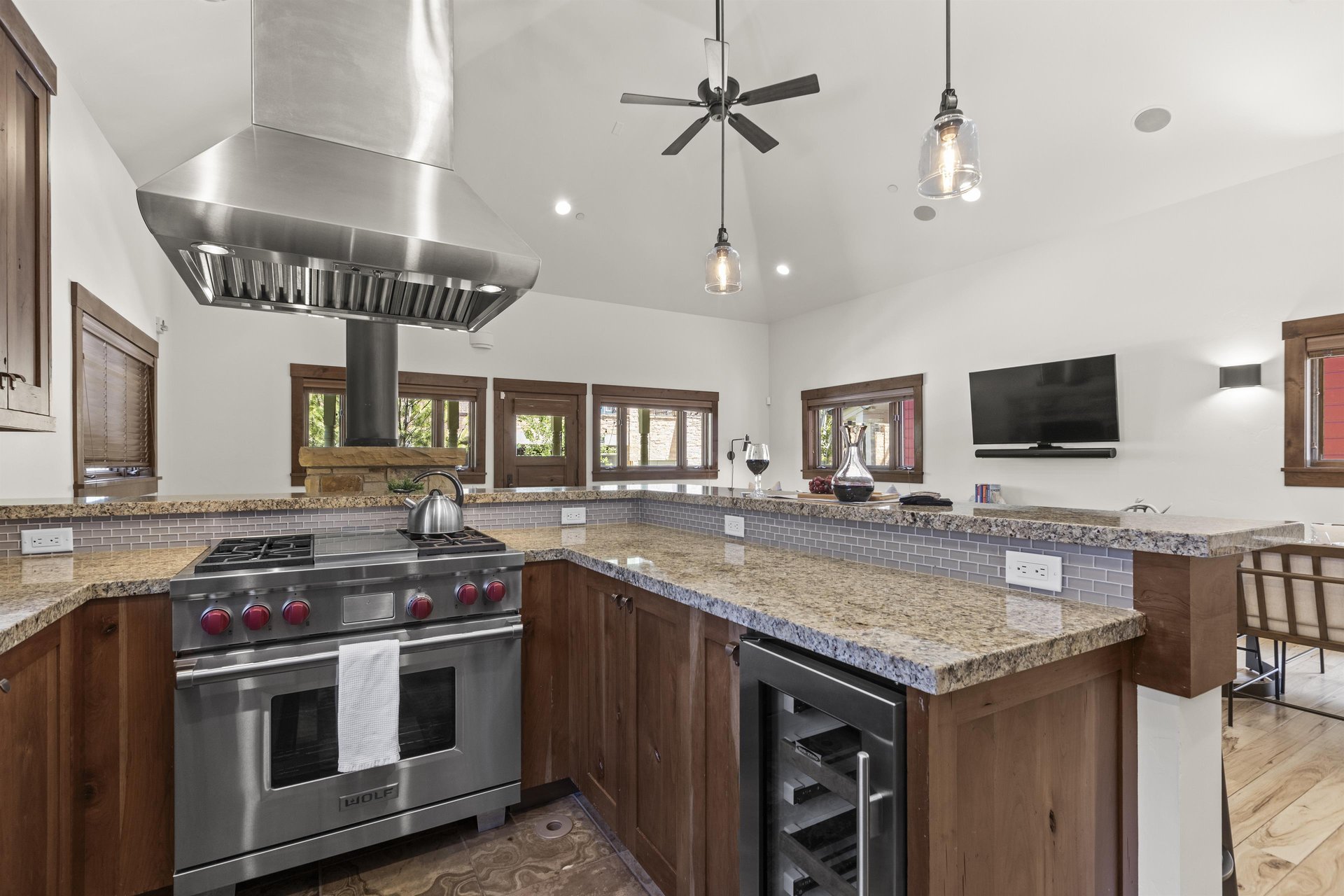Town Lift Chalets kitchen with breakfast bar, stainless steel Wolf range, stainless hood vent, and wine fridge.
