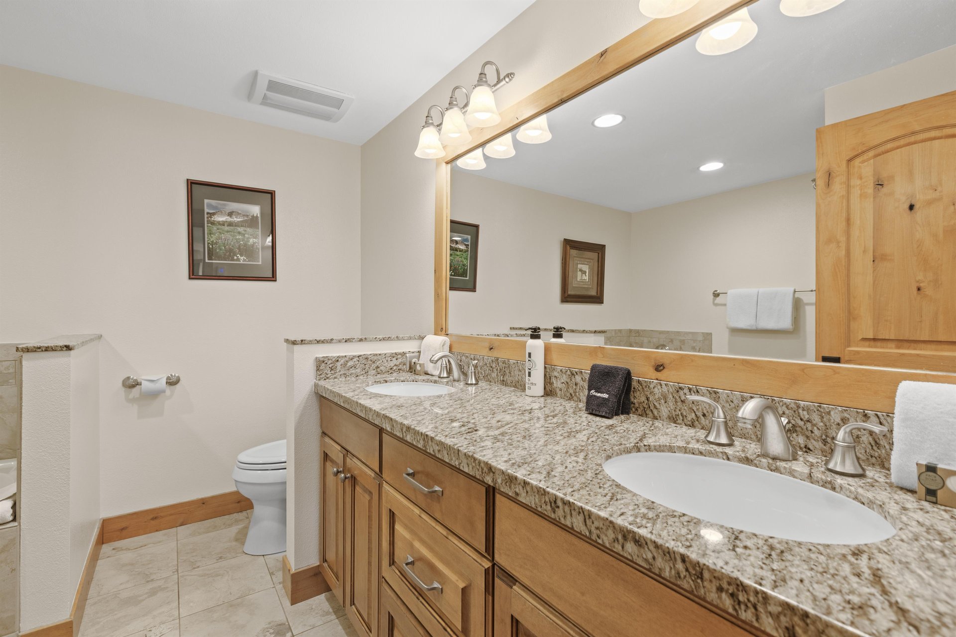 The en suite bathroom has a double sink vanity.