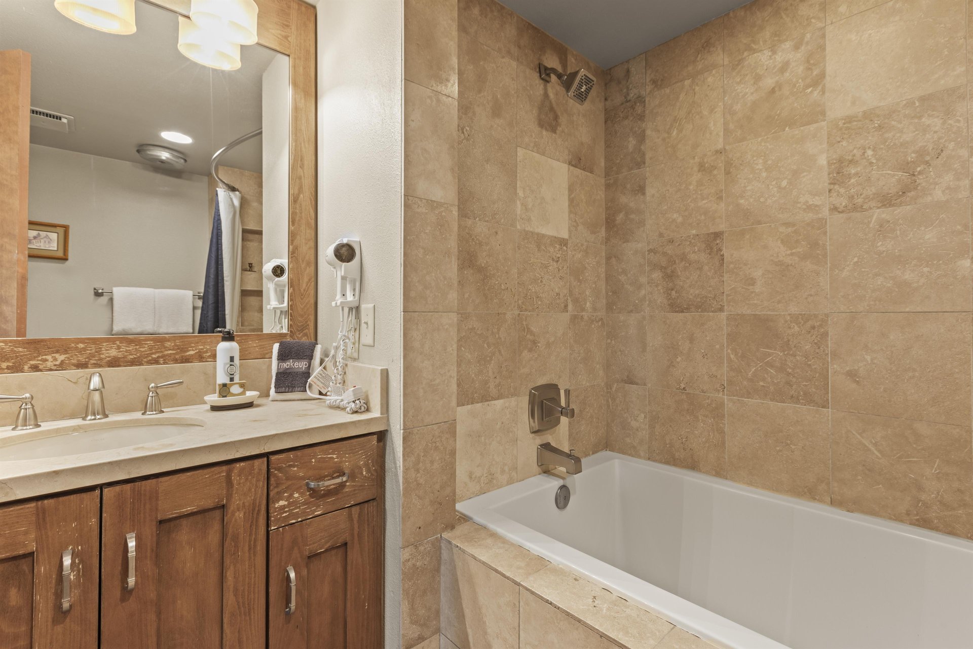 The en suite bathroom has a single sink vanity and bathtub and shower combination.