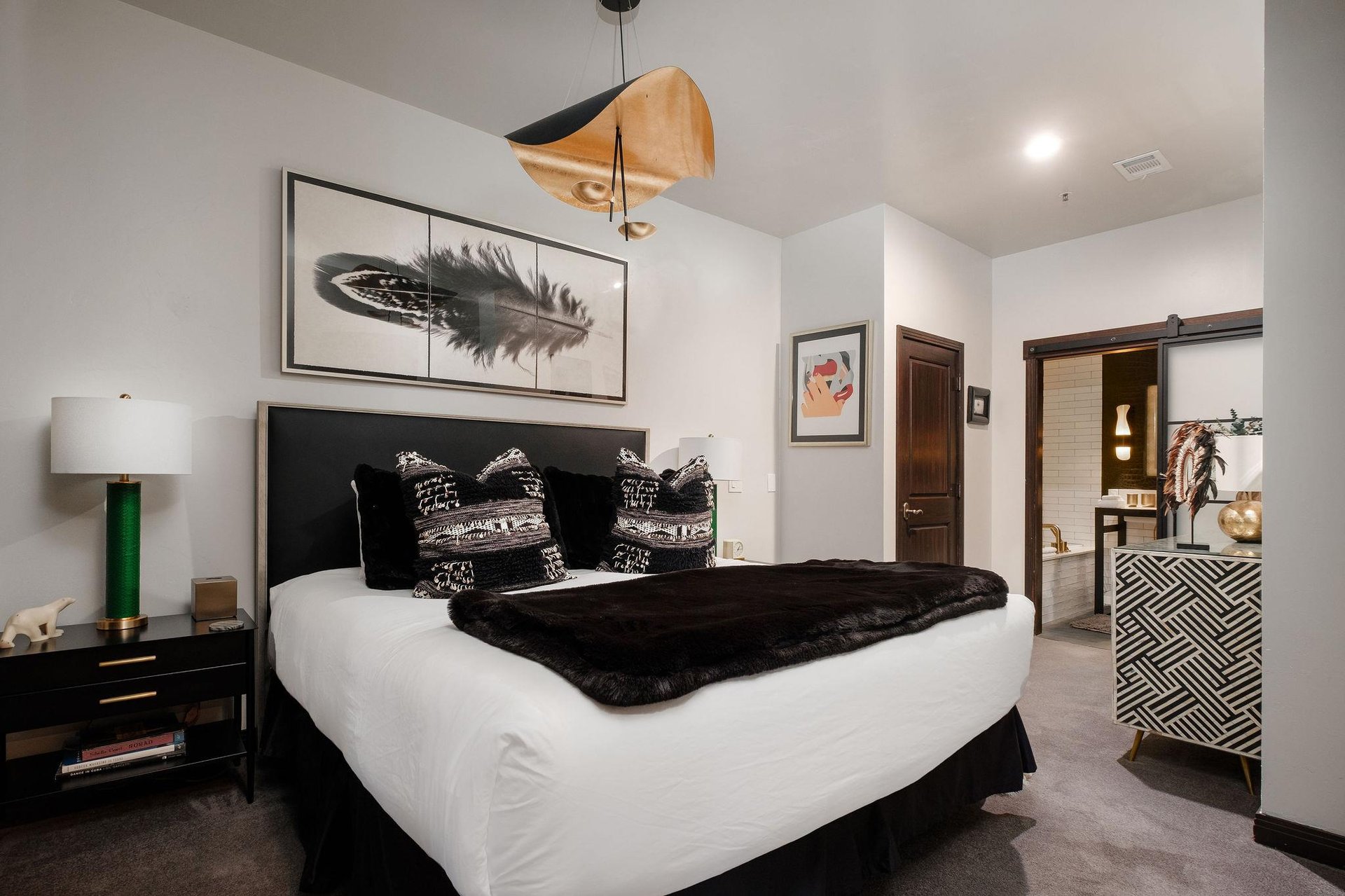 The main room with king bed and black and white furnishings with touches of gold.