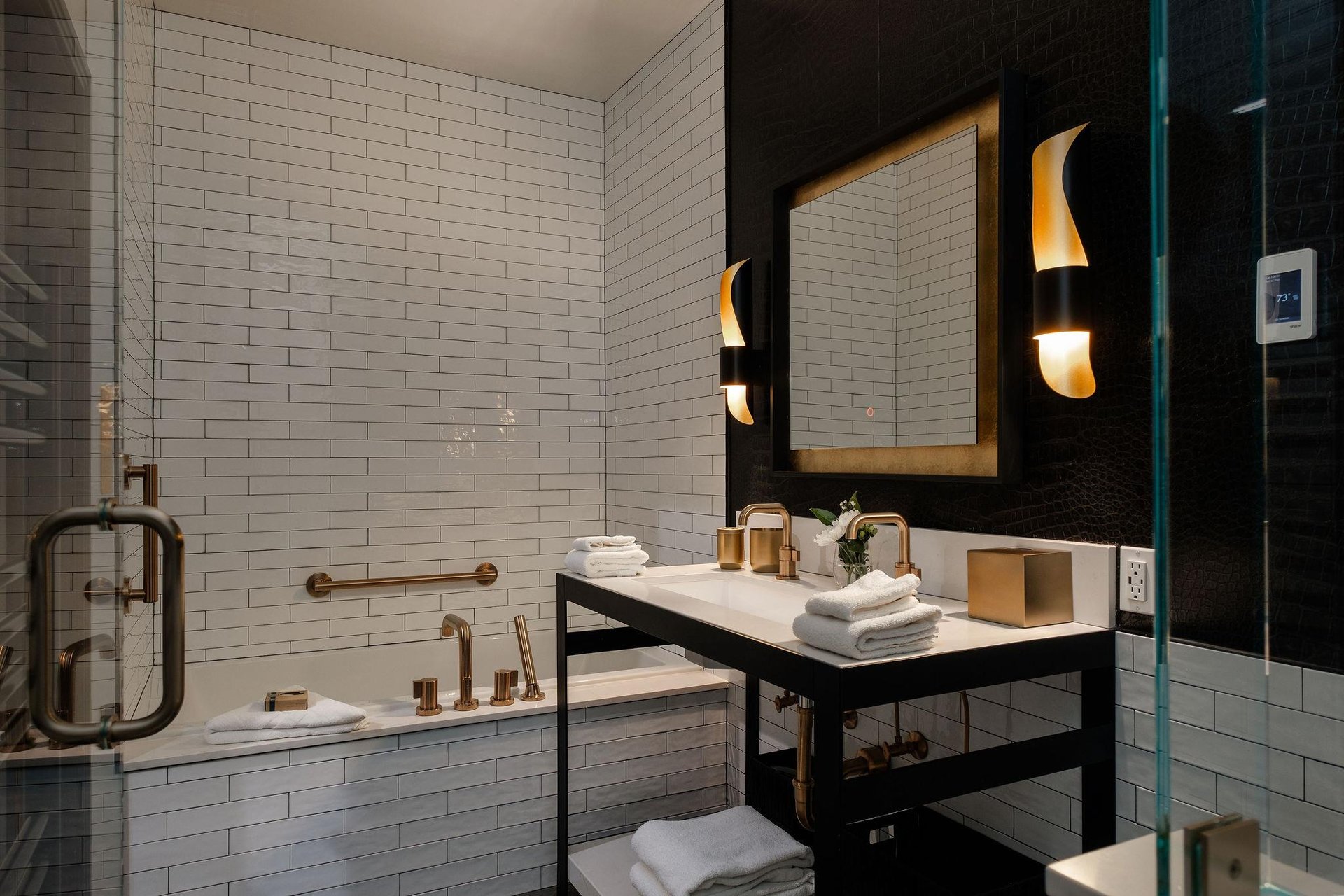 The en suite bathroom done in black, white and gold and deep soaker tub.
