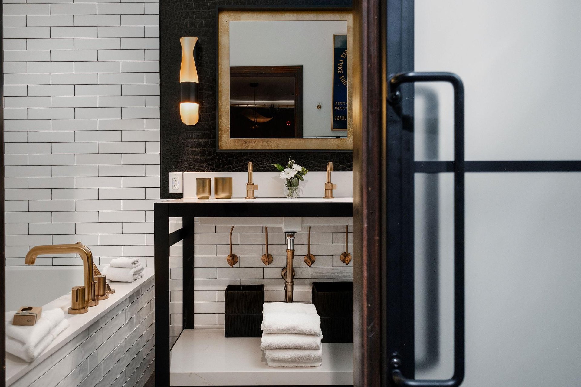 The en suite bathroom done in black, white and gold and two sink vanity.