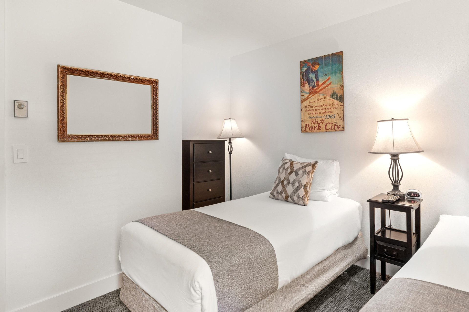 The second bedroom has two twin beds and tall dresser.