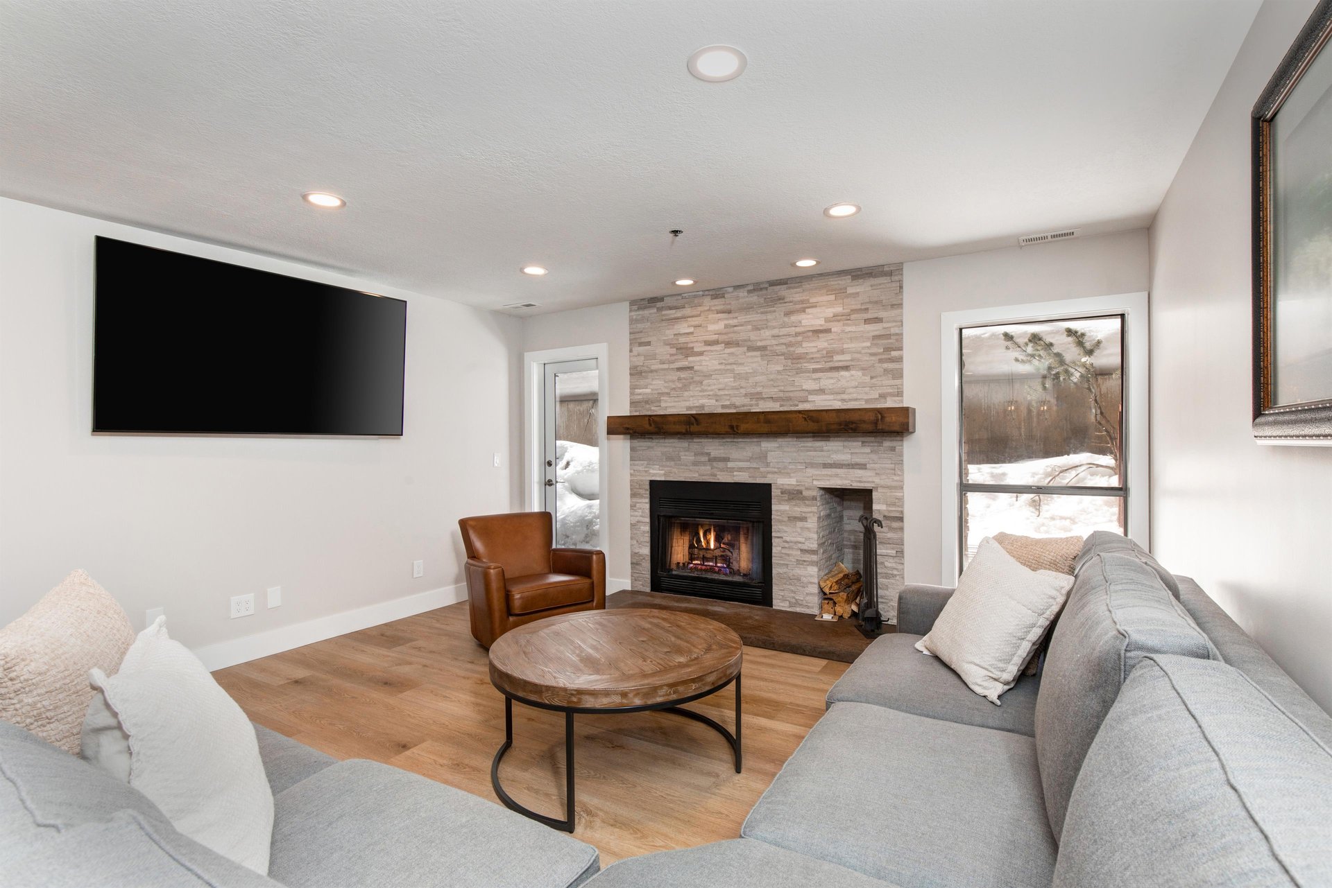 The living area offers comfortable furnishings, flat screen TV, and gas burning fireplace..