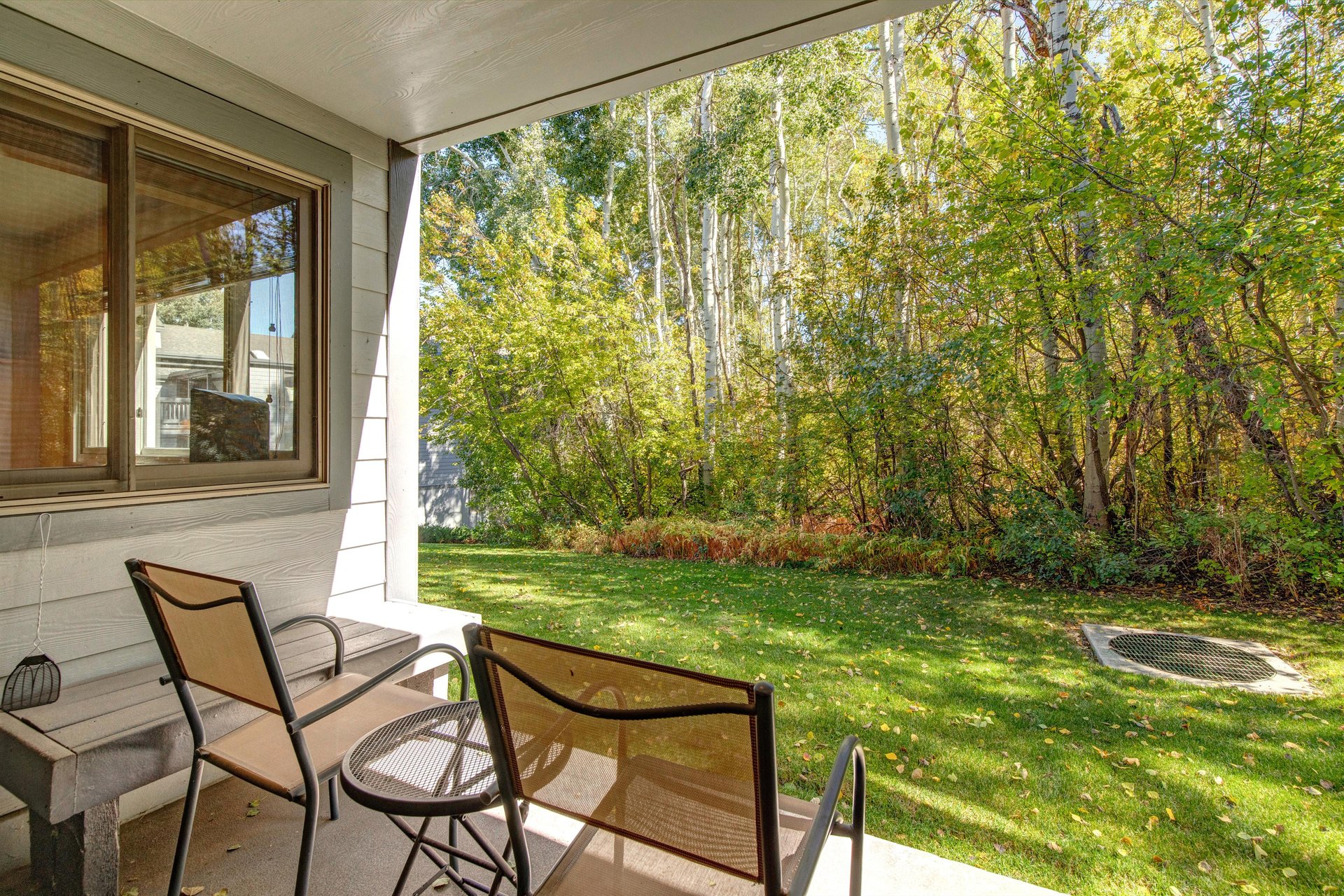 The private patio overlooking a aspen grove and green lawn.