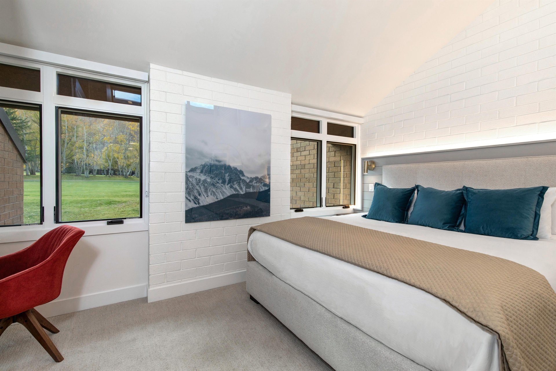 A main suite with a king size bed and windows overlooking the golf course.