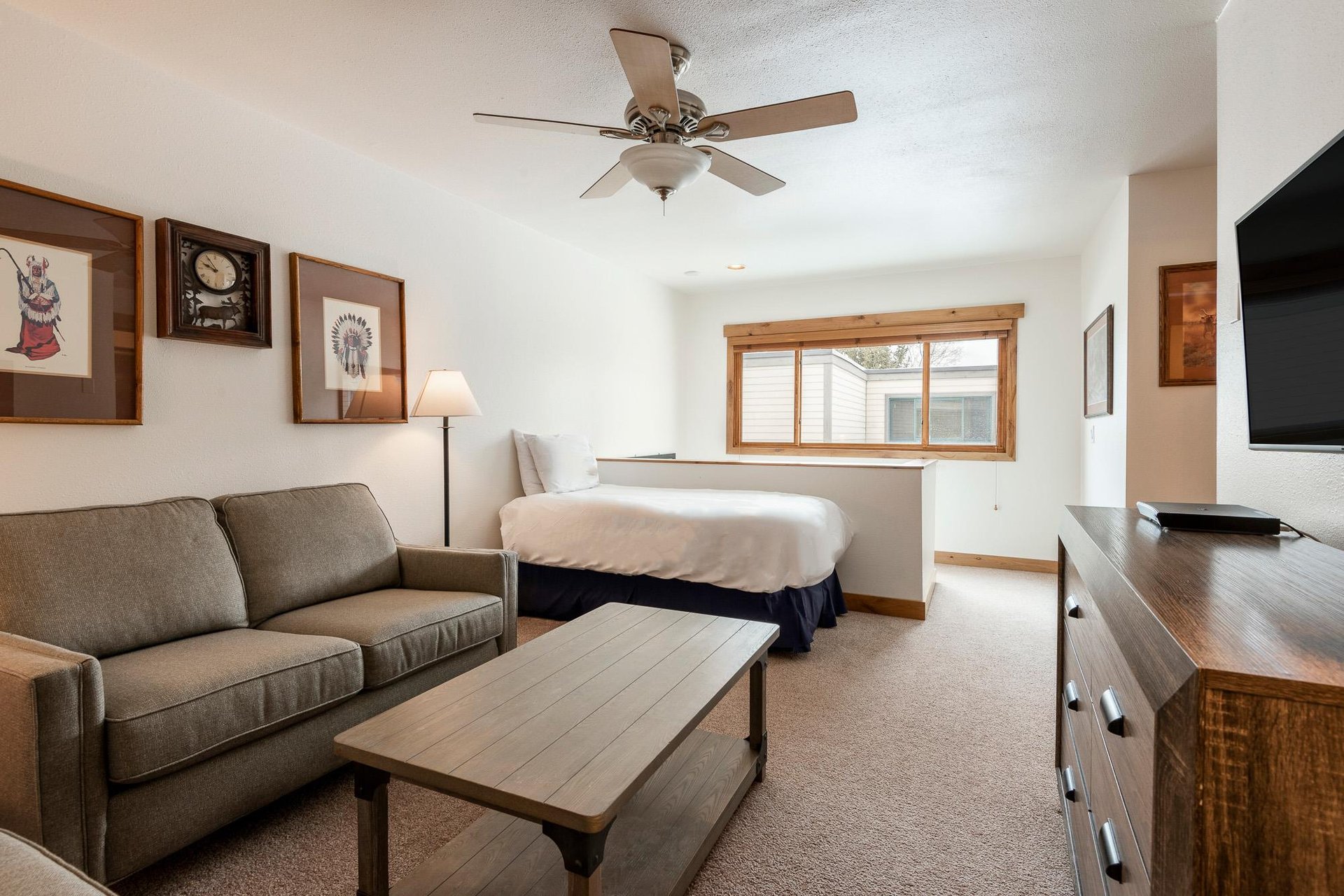 Loft area with twin bed and second living room with a TV.