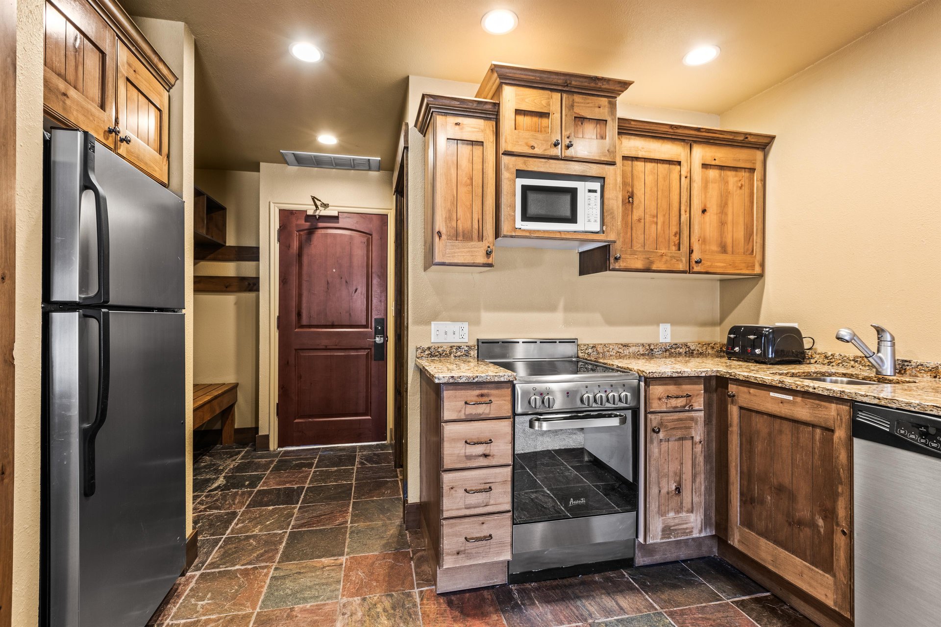 The efficient kitchen with oven, refrigerator, microwave, and dishwasher.
