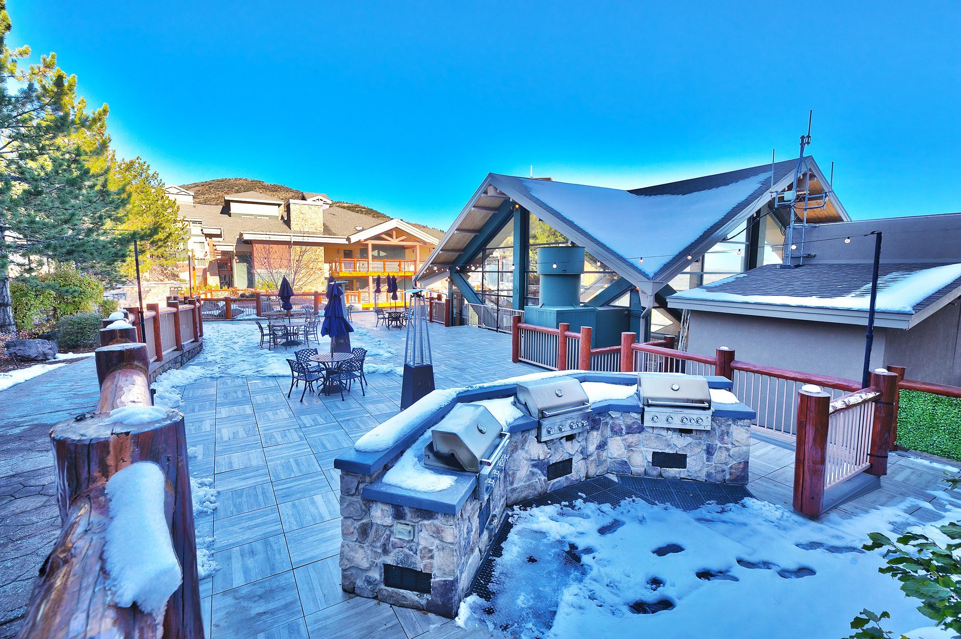 Shared outdoor patio space with chrome gas grills, seating areas, heat lamps