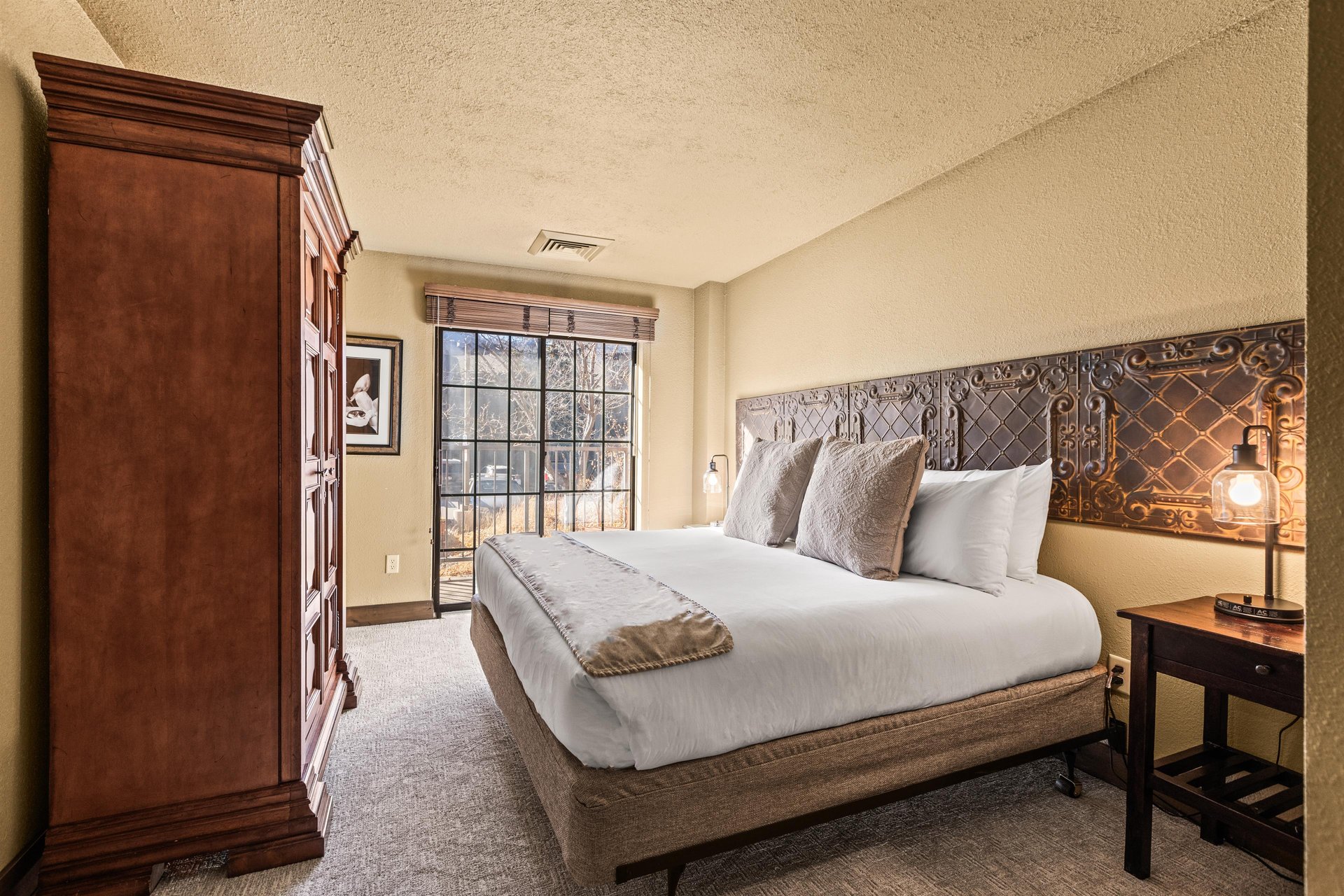 The main suite bedroom with a king size bed and large sliding glass door leading to a private patio.