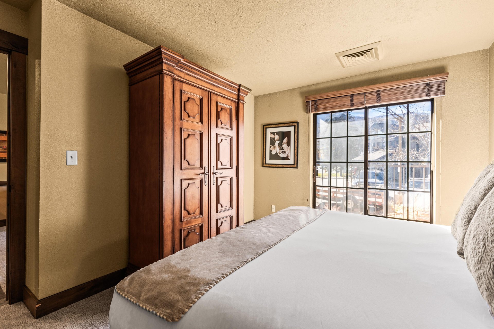 The main suite bedroom with a king size bed and large sliding glass door leading to a private patio.