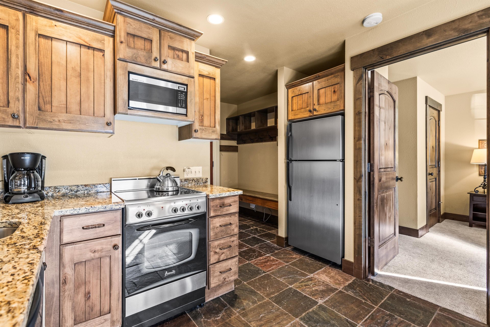 The efficient kitchen with oven, refrigerator, microwave, and dishwasher.
