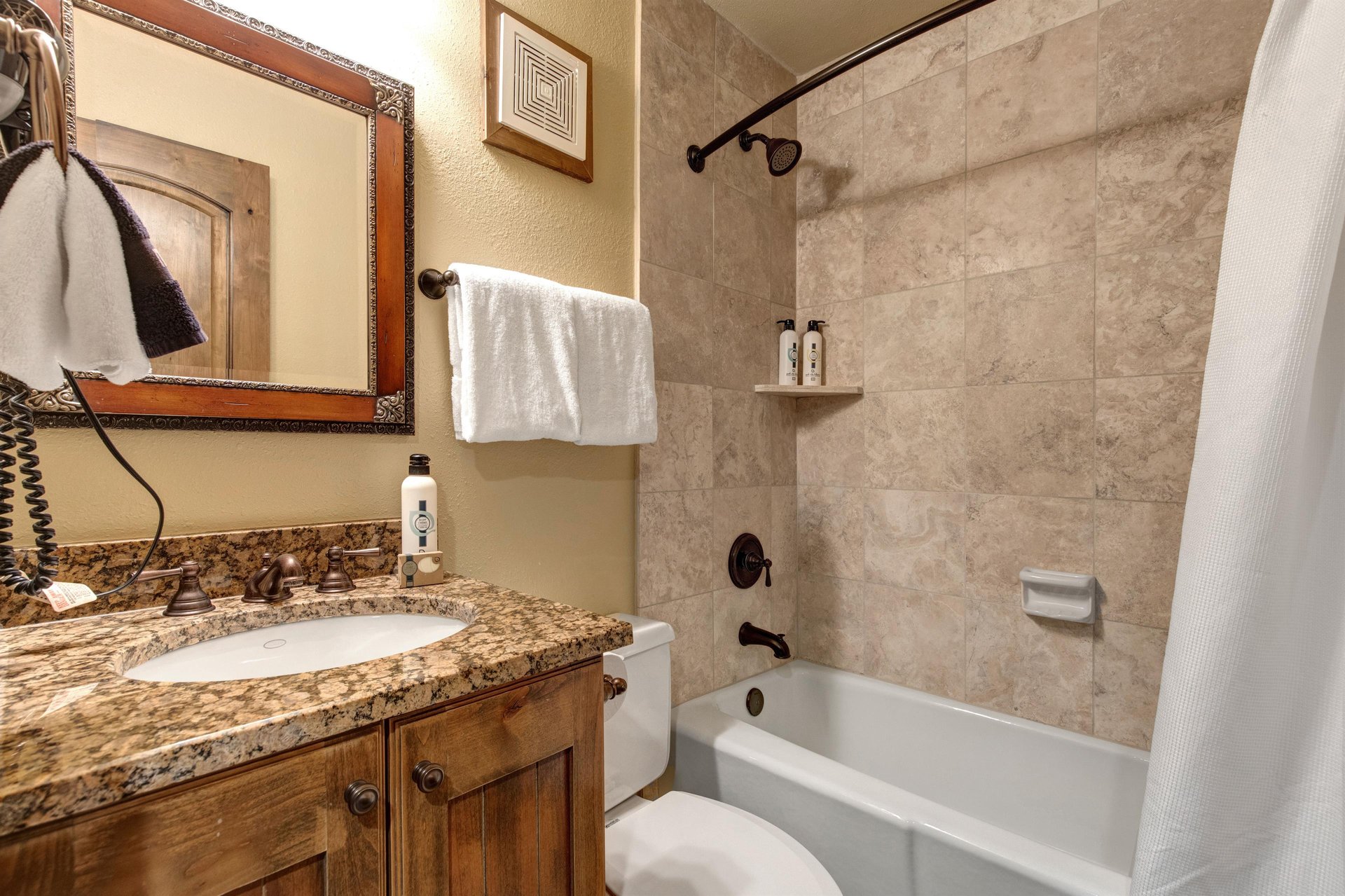 The en suite bathroom has a bathtub and shower combination.